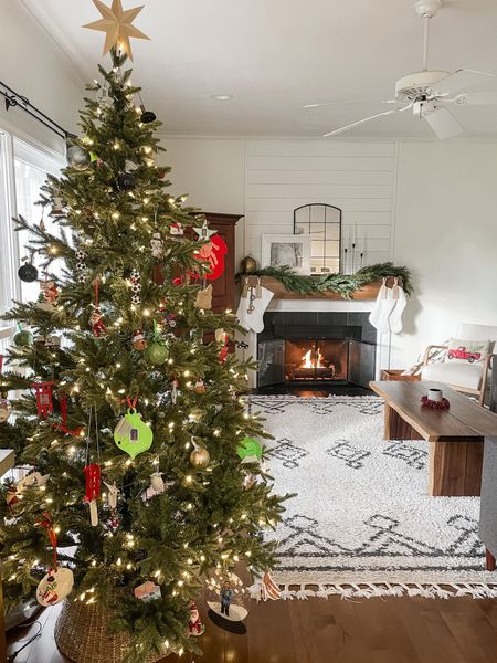 Christmas home decor.  Christmas tree from Home Depot.  Christmas tree gold bulb ornament.  Rugs USA Moroccan area rug.  Neutral 8 X 10 area rug.  Black arched mirror.  White faux fur stockings.  Spruce Christmas garland.  Modern wooden trees.  Black candlestick holders from Amazon.  Gold antique bells.  7.5 feet artificial Christmas tree.  

#LTKhome #LTKHoliday #LTKSeasonal