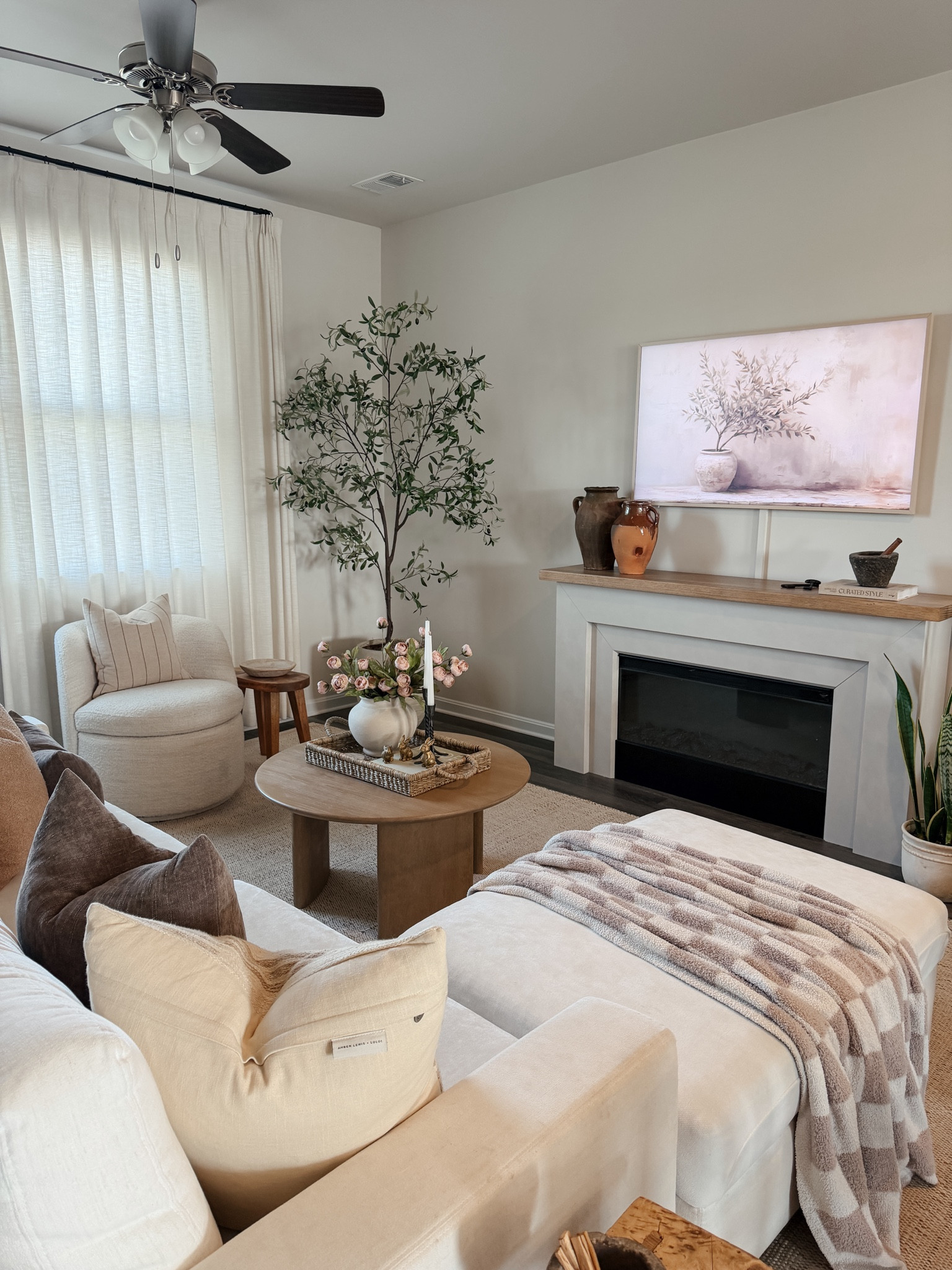 Still loving this cozy neutral corner of our home 🤍 The mix of textures, warm wood tones, and simple pieces makes it feel so calm and inviting. Sharing all the details because so many of these are affordable finds that give that designer look for less.

🏷️ neutral home decor, organic modern home, cozy living room, frame tv look for less, electric fireplace, jute rug, white couch, round coffee table

#LTKHome