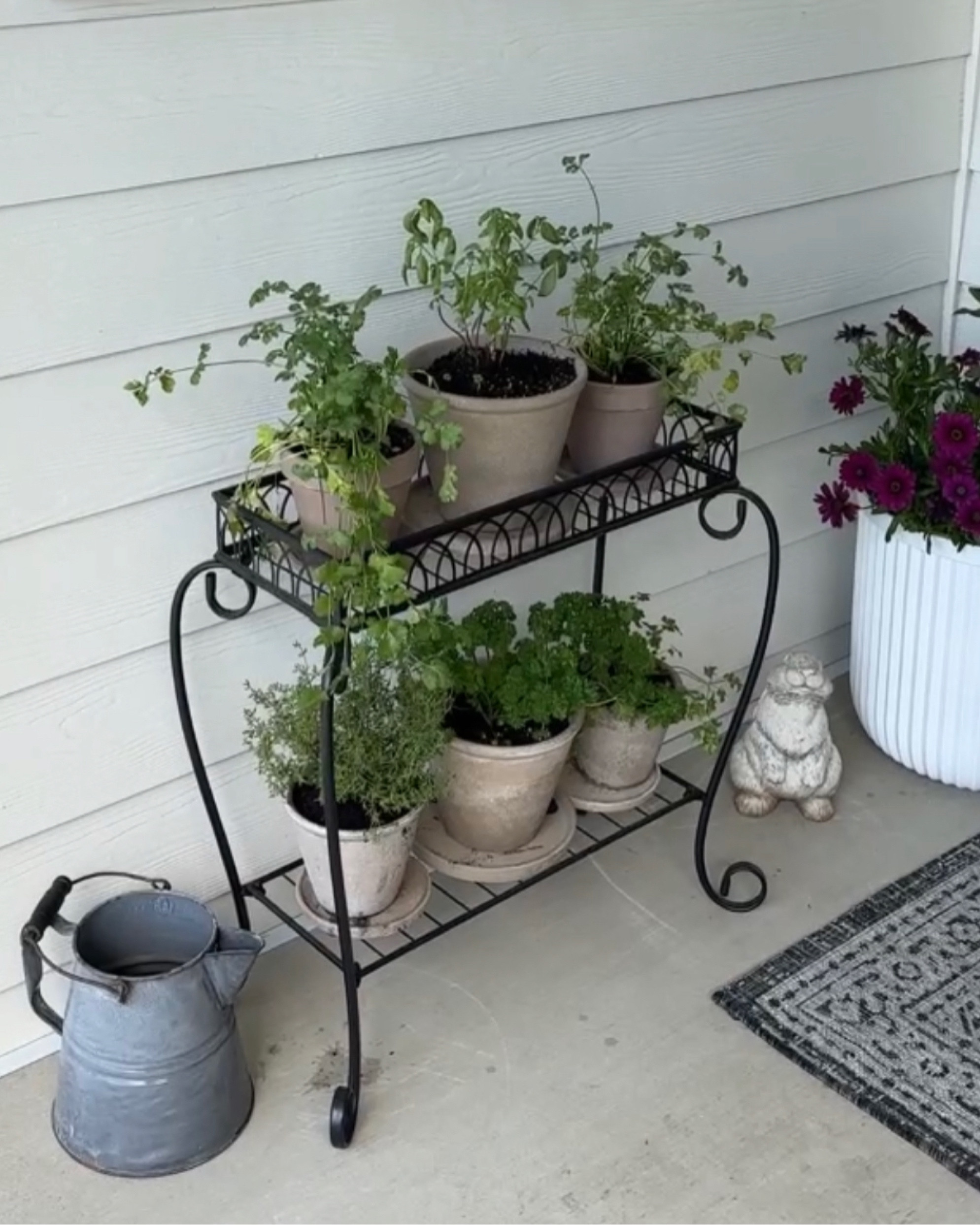 Porch garden using a plant stand and clay pots. 

#LTKfamily #LTKSeasonal #LTKhome