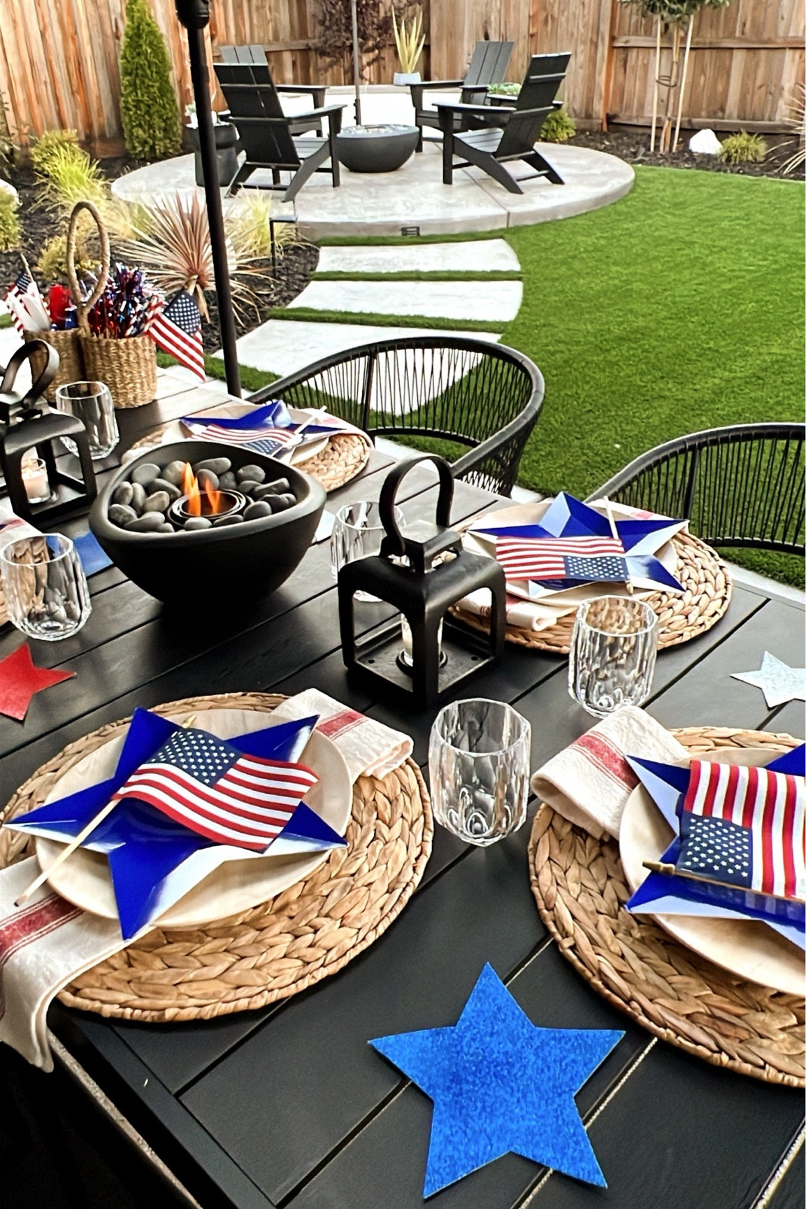 Alfresco dining all summer long! Black metal outdoor table, table, top fire pit, patriotic, table, setting, woven Rafia round placemats, melamine outdoor dinnerware. 

#LTKSeasonal #LTKHome