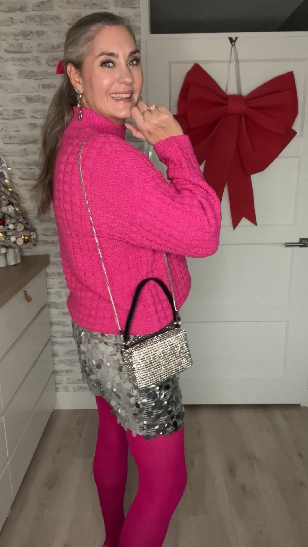7 days of non-black party outfits - day 4. A hot pink knitted sweater (HEMA), silver sequin mini skirt, pink velvet bow, pink heels, silver heart earrings (Zeeman) and strass bag (Norah), pink tights (Snag). 

#LTKeurope #LTKpartywear #LTKnederlands