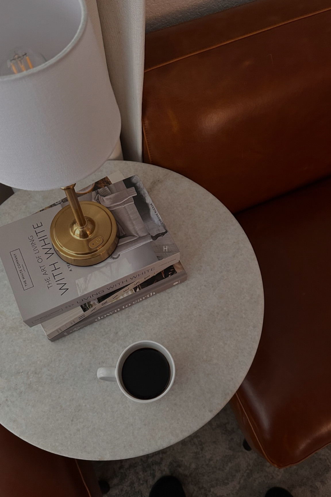 Battery powered table lamp

Faux book storage box for remotes

Coffee table books

Mugs

Leather chairs

Area rug

#LTKStyleTip #LTKHome