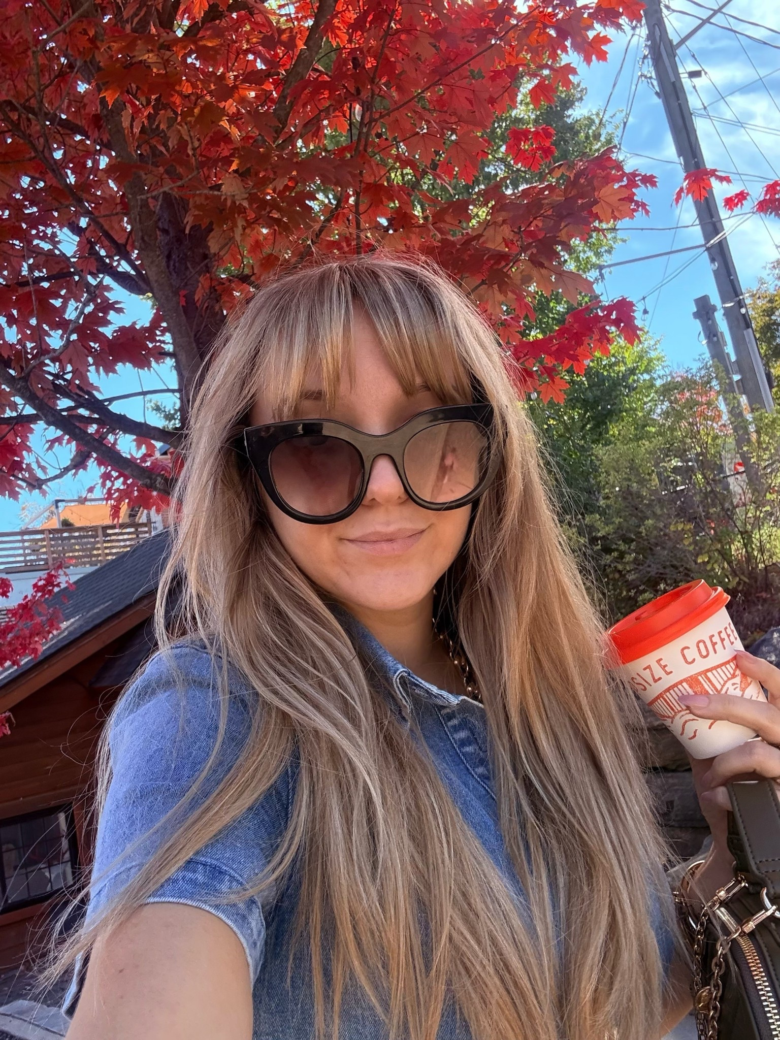 Denim, sunshine, and a perfect coffee moment at @capsize.coffee while strolling Bracebridge in October 🍂🍁🍂