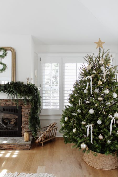 Our first tree in our home ✨ Proudly fits the space well and can’t wait to collect more ornaments to overfill it over the years! Shop my entire holiday home tour which is now updated to inspire your tree! View and shop via the link in bio.
•
•
•
Christmas tree, tree bow, woven tree star, tree topper, neutral Christmas tree, tree collar, gold ornaments, white ornaments, live tree decorating Fireplace mantel garland, Christmas garland, affordable holiday home decor, Michael’s garland, stocking decor, holiday home tour, neutral Christmas, simple Christmas decor, brass decor, holiday home inspo, candle holder, mirror, brass decor, nutcracker, hanging bells 

#LTKSeasonal #LTKhome #LTKHoliday