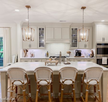 Brass lanterns and French cafe counter stools complete this traditional modern farmhouse kitchen. 