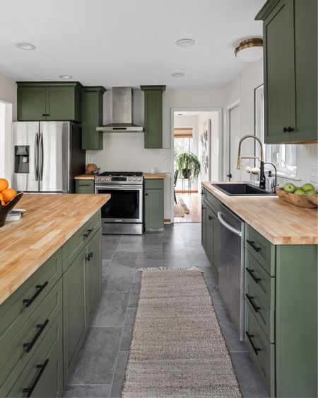 A pop of color in the cabinetry mixes with light wood butcher block countertops and a clean backsplash for the perfect warm, welcoming nature tones.

#LTKhome