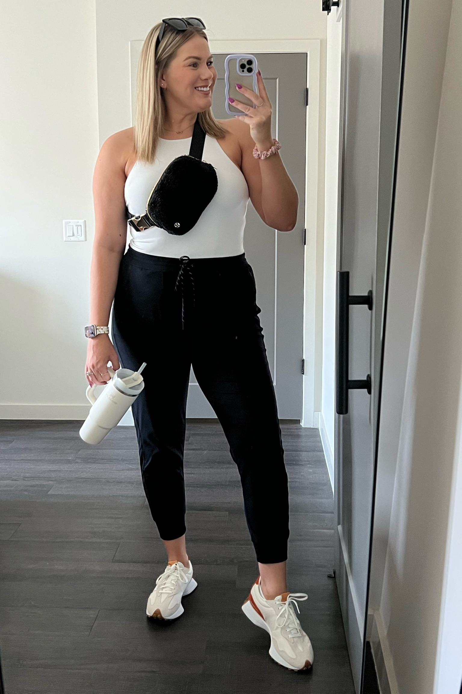 Athleisure look of the day that would also make a great travel outfit. 
Zella black joggers 
Express white bodycon bodysuit 
New balance 327 sneakers 
Lululemon belt bag
Stanley 30 oz quencher 
Amazon sunglasses 
Amazon Apple Watch band 
Amazon purple iPhone case 
Gold Huggies small hoop earrings 

#LTKtravel #LTKFind #LTKstyletip