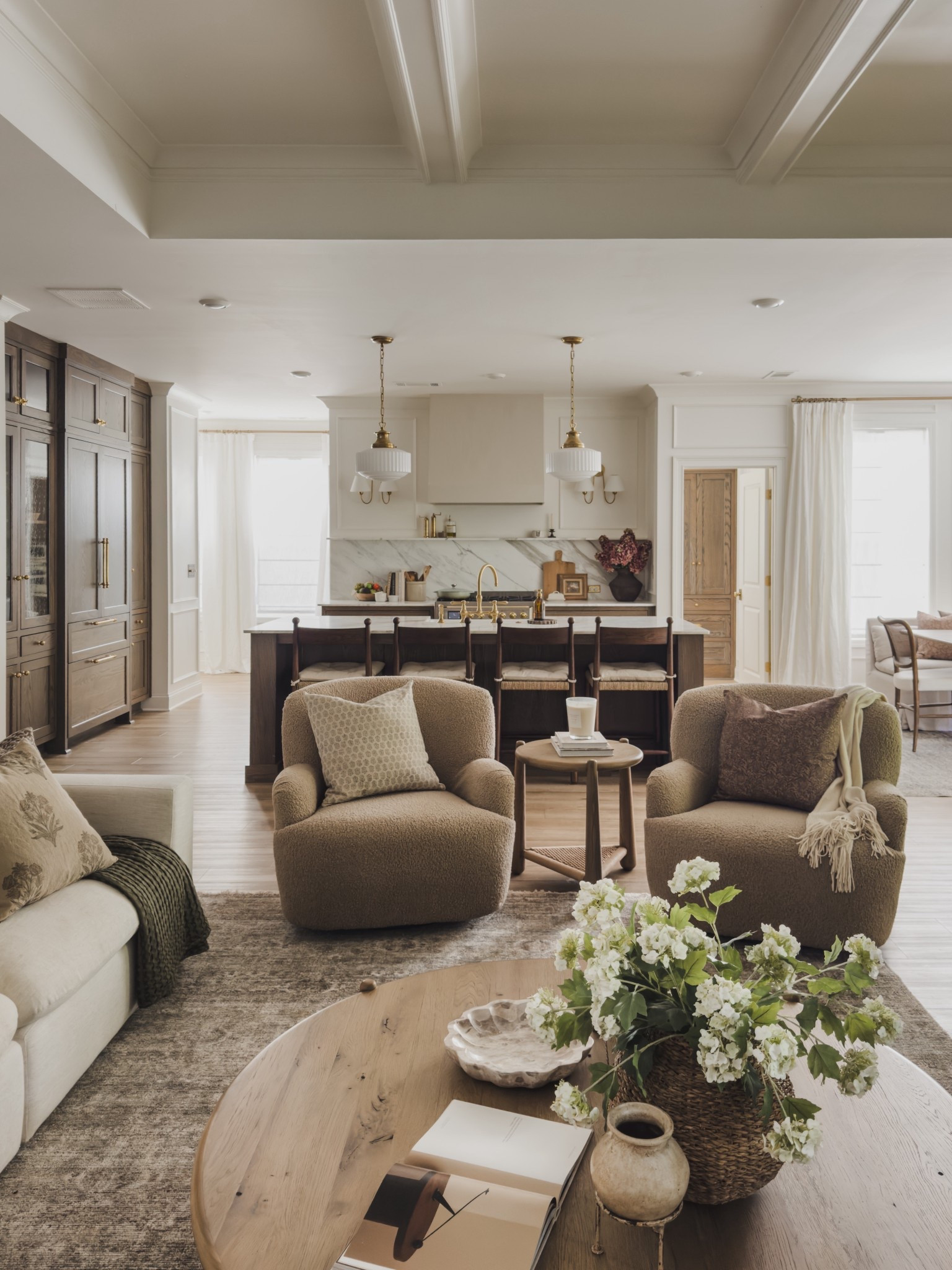 Loving the new layout in my living room space. I struggled with the flow for a while with two traditional sofas. With the new addition of these cozy accent chairs it gives a great walkway and focal point between the living room and kitchen.

Home finds, living room refresh, collected style, neutral home inspo, Nancy Meyer’s vibes, cozy sectional, accent chair, oversized round table, neutral area rug, vintage style rug, ceiling fan, gold detail, frame tv, ottoman favorites, neutral wood sideboard, mirror details, table lamp, faux florals, fireplace surround, accent table, Castlery, Four Hands, Wayfair, found it on Amazon, Amazon Prime, Samsung, Etsy, Amber Lewis, Loloi, McGee and Co, Visual Comforts, Pottery Barn, TwoPages, roman shades, cozy throw blanket, throw pillow, upholstered sofa, linen detail, linen curtain, shop the look!