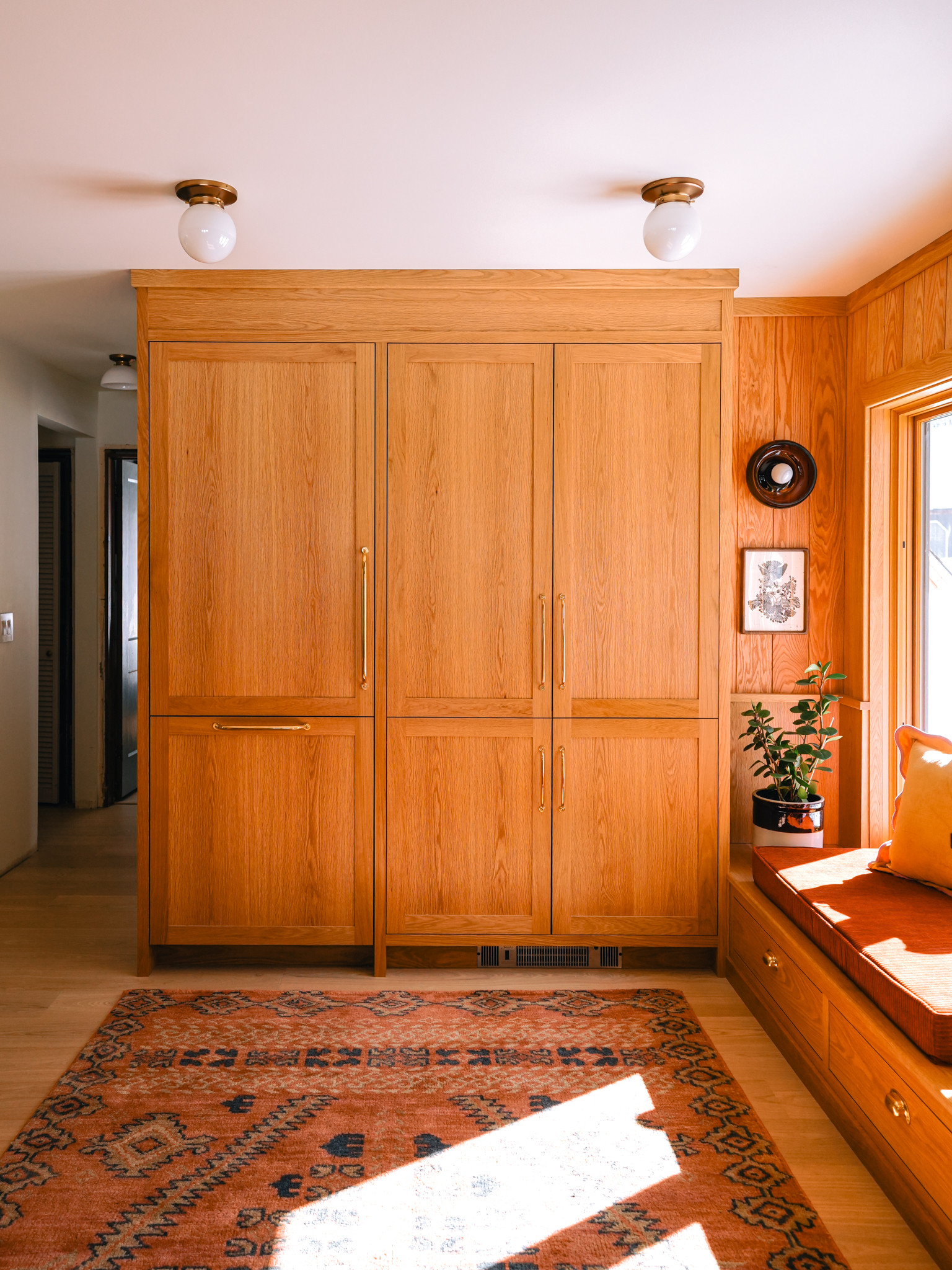✨ Our Pantry & Window Seat ✨ Much of our kitchen remodel was based around this window and the natural light that it provides. We added a bank of cabinetry underneath and topped it with a thick cushion. With the funky amber sconce and the cozy rug, it's now the most coveted spot by our dogs (and us).  

 #LTKHome