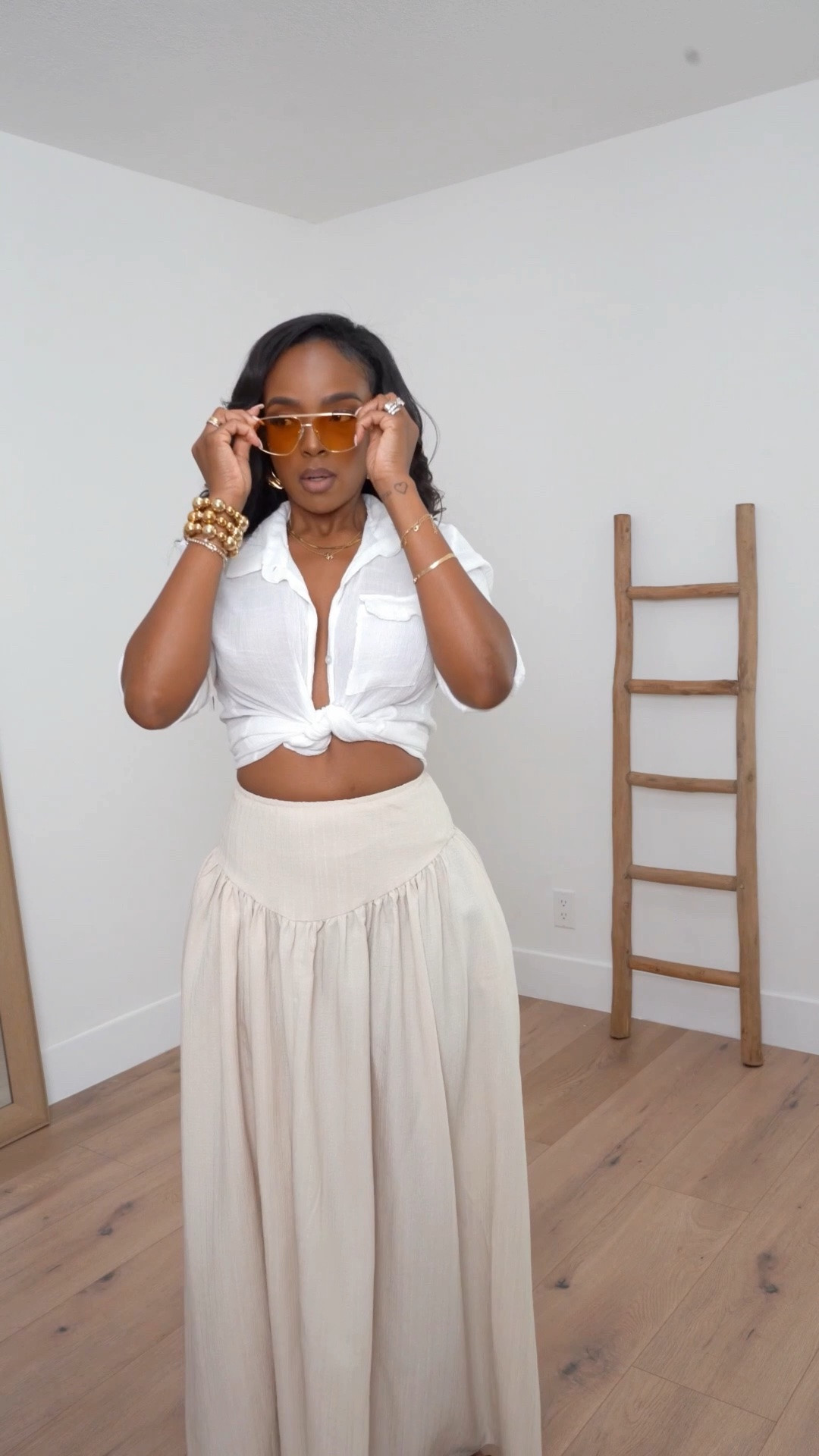 Hi Babes!

Okay this outfit is the definition of effortless coastal chic. The tied white button-down paired with these flowy neutral wide-leg pants creates such a relaxed yet elevated look that feels straight out of a luxury resort.

I love how the movement of the pants balances the cropped top, while the gold jewelry and sunglasses add that polished finishing touch. It's comfortable, flattering, and perfect for warm-weather days.

Where to wear this:
• Beach vacations
• Resort brunches
• Cruise days
• Summer shopping trips
• Casual lunch dates

Undergarments: Nude seamless bra or nipple covers and seamless thong recommended for the smoothest fit (linked).

Everything is linked below!

xx Kira | IG: KirasFashionFinds

34D - 27 - 40 • Size Small or 4