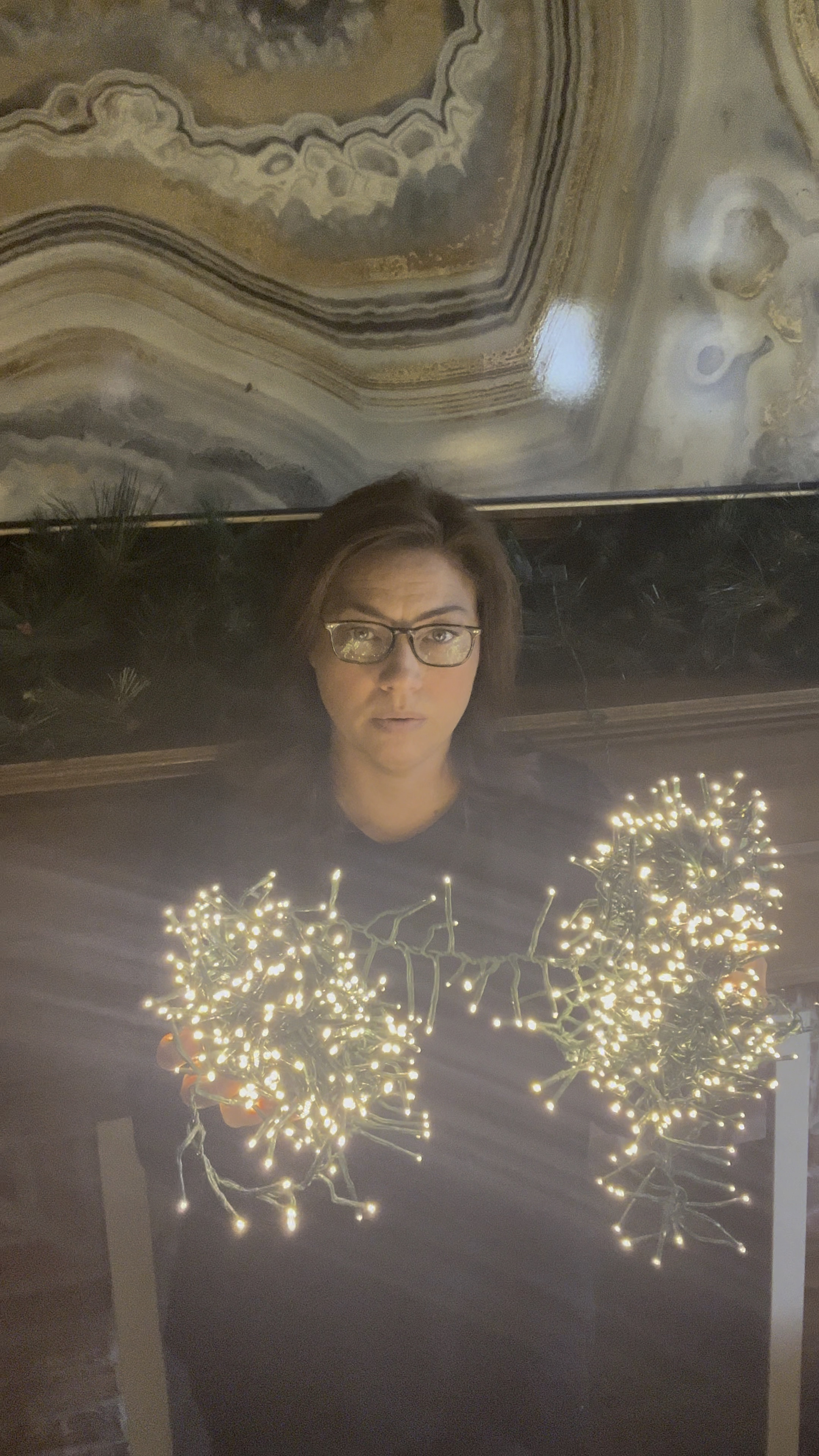 Adding my first 40’ cluster light to my mantel garland.  Putting the first half of the strand down in the garland and keeping the second half in reserve to bring back through once I have my decor on the garland.

#LTKHoliday #LTKhome 

#LTKSeasonal