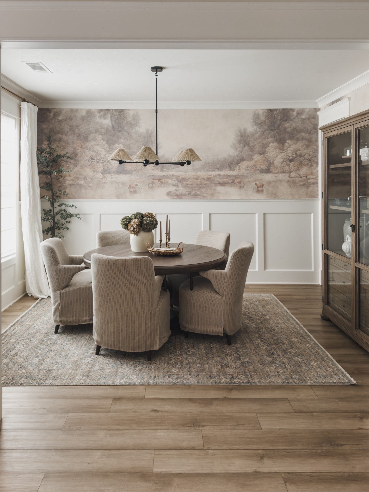 After much trial and error, a true labor of love, and still learning my style for this home - my dining room finally feels complete. Between layers of texture, pattern, and a pop of moody tones, my dining space combines all of the things I love that is functional and a statement as soon as you step inside.

Home finds, neutral home inspo, dining room refresh, timeless home style, collected style, moody home inspo, round dining table, linen upholstered dining chairs, chandelier details, dining hutch, vintage style area rug, linen curtain, brass detail, neutral wood tones, faux florals, Four Hands, Pottery Barn style, Amber Lewis, Loloi, Two Pages, Etsy, Afloral, Wayfair, shop the look!

#LTKHome #LTKSeasonal