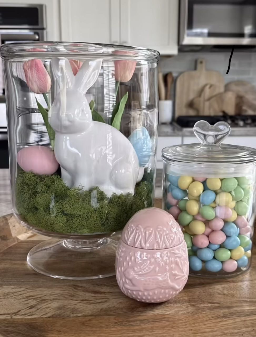 Love how they used Easter candy and Easter decor to make this Easter centerpiece fun, colorful, and eye catching with the different heights and textures! #easterdecor #eastertabledecor #eastercenterpiece #easterkitchendecor

#LTKHome #LTKSeasonal #LTKStyleTip