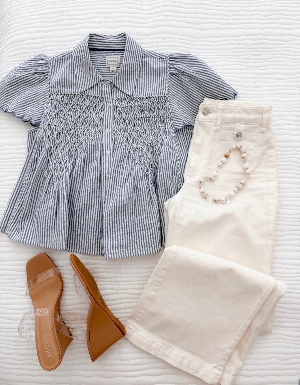 This outfit is giving classic summer style with a polished twist. The striped smocked top feels elevated and boutique-worthy, and these white wide leg jeans are one of those pieces you’ll reach for all season long. Finished with neutral wedges and a beaded bracelet for an easy look that works for brunch, errands, or summer dinners.

Summer outfit, White jeans outfit, Striped blouse, Wide leg white jeans, Casual chic style, Summer fashion inspiration, Neutral sandals, Everyday summer look, Coastal style outfit, Boutique fashion, Vacation outfit idea, annabrstyle

#LTKdayinmylife #LTKOver40 #LTKSeasonal