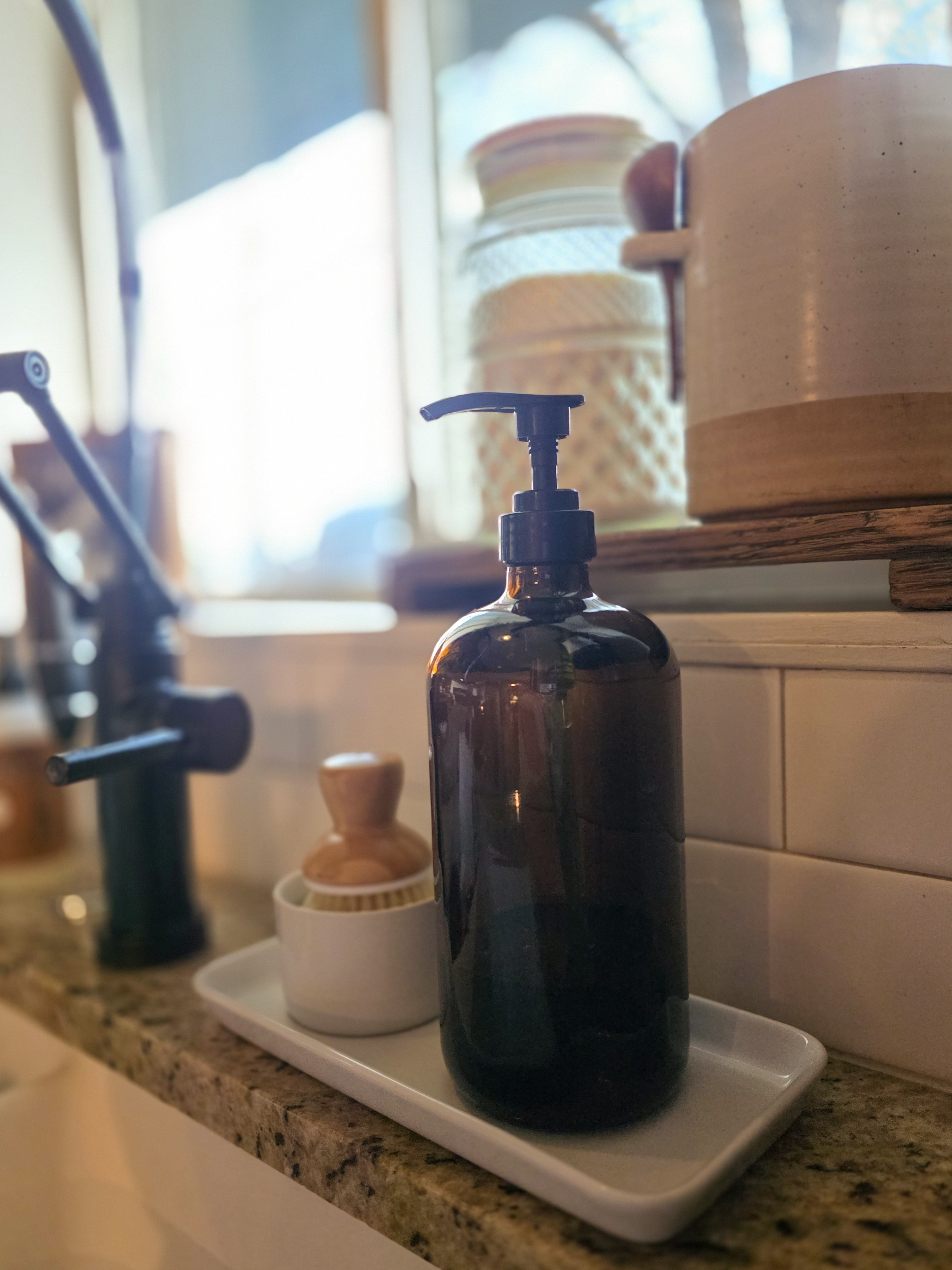 This little sink tray setup makes doing dishes feel less like a chore, with an amber glass soap dispenser and a wooden scrub brush that actually look nice sitting out. Small swaps like this are such an easy way to make an everyday space feel a bit more put together. #kitchenstyle  

 #LTKHome
