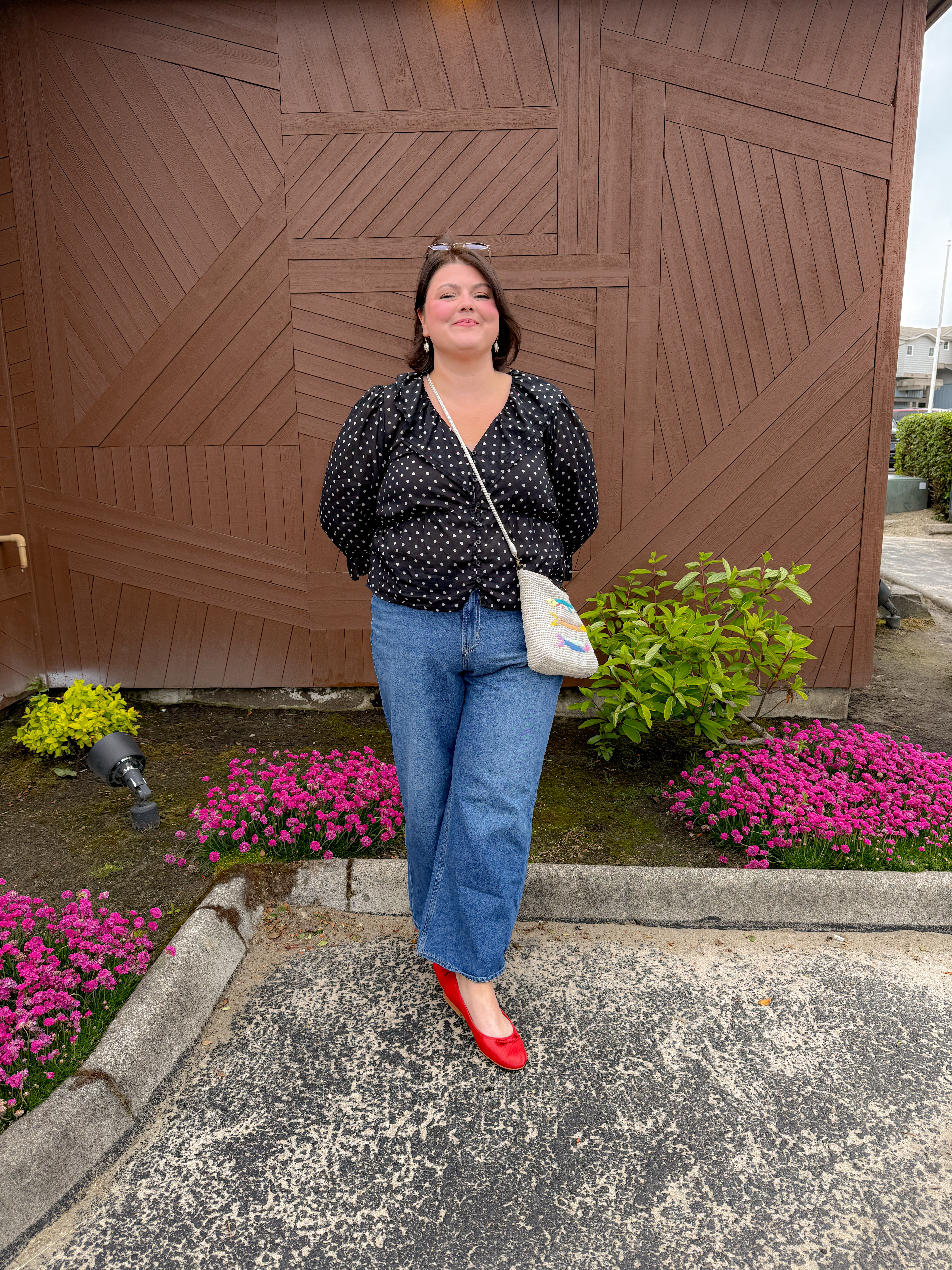Polka-dot blouse, wide-leg jeans, red flats: my new go-to "effortless but not really" formula. This blouse runs a little romantic with the puff sleeves, so it dresses up a basic denim fit without trying too hard. The red flats are doing all the work today, they're what turns "jeans and a top" into an actual outfit. Linked everything, including this little woven bag, on my LTK!
Hashtags

#LTKstyletip #LTKfindsunder100 #LTKshoecrush #ootd #outfitinspo #everydaystyle #widelegjeans #polkadotblouse #redflatsoutfit #summerstyleinspo 

 