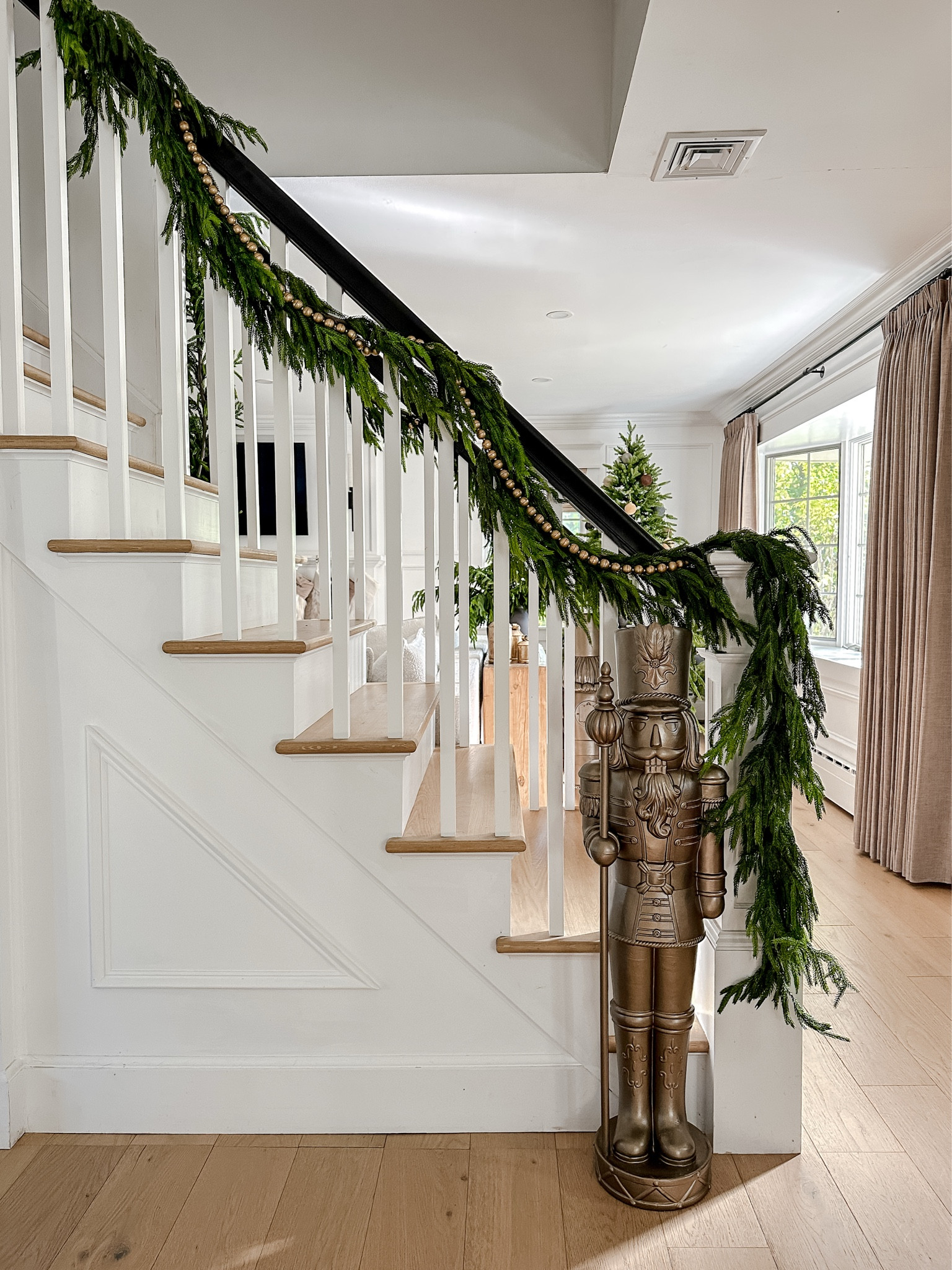I spray painted this perfect sized nutcracker with an antique bronze finish. My staircase railing is wrapped with artificial Norfolk pine garland and gold wood bead garland. 


#LTKHoliday #LTKSeasonal #LTKSaleAlert