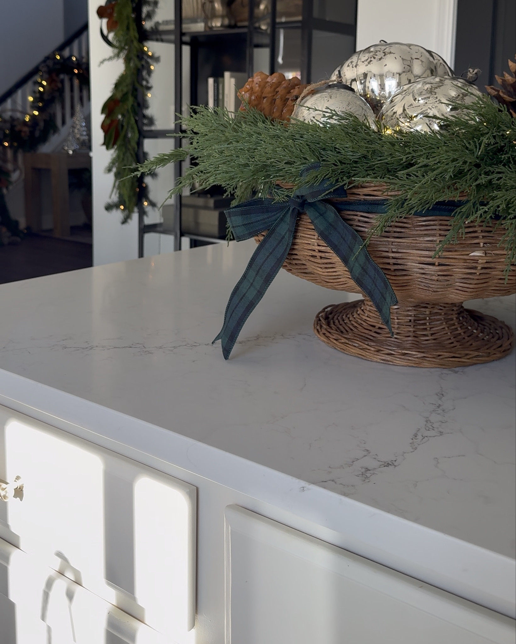 This is my black arched cabinet Christmas look for 2025. I kept it fairly simple on the inside with things I own like cookbooks, vintage brass horse book ends, terra-cotta vases, wooden bells, and draped mixed green garland with ribbon and magnolias on the outside.

#LTKHoliday #LTKSeasonal #LTKHome