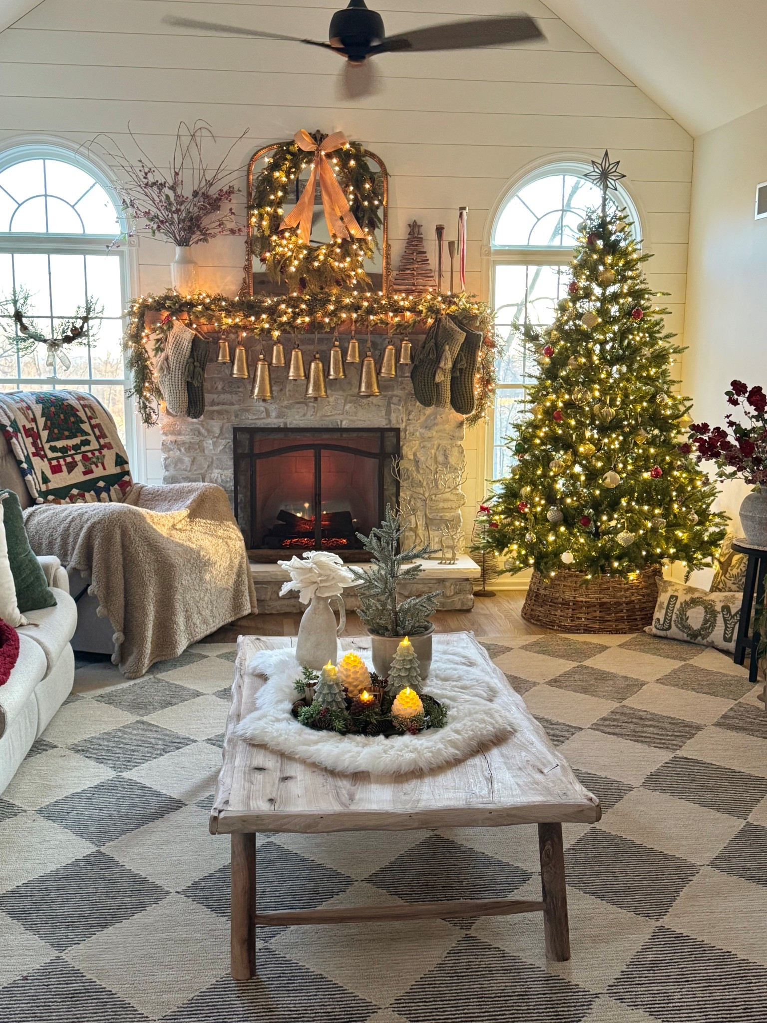 Hanging brass bells on a rod - bells come in varying sizes and are so beautiful. Confetti fleck waffle knit stockings. Trio of brass candlesticks. Custom made reclaimed wood coffee table. White fur rug used as table runner. Pretty white fabric poinsettia stems. Gold deer  Flameless pinecone and tree candles. Beige and gray geometric neutral rug that looks great in any space! Electric fireplace. Alpine Fir King of Christmas artificial tree  

#LTKHome #LTKHoliday #LTKSeasonal