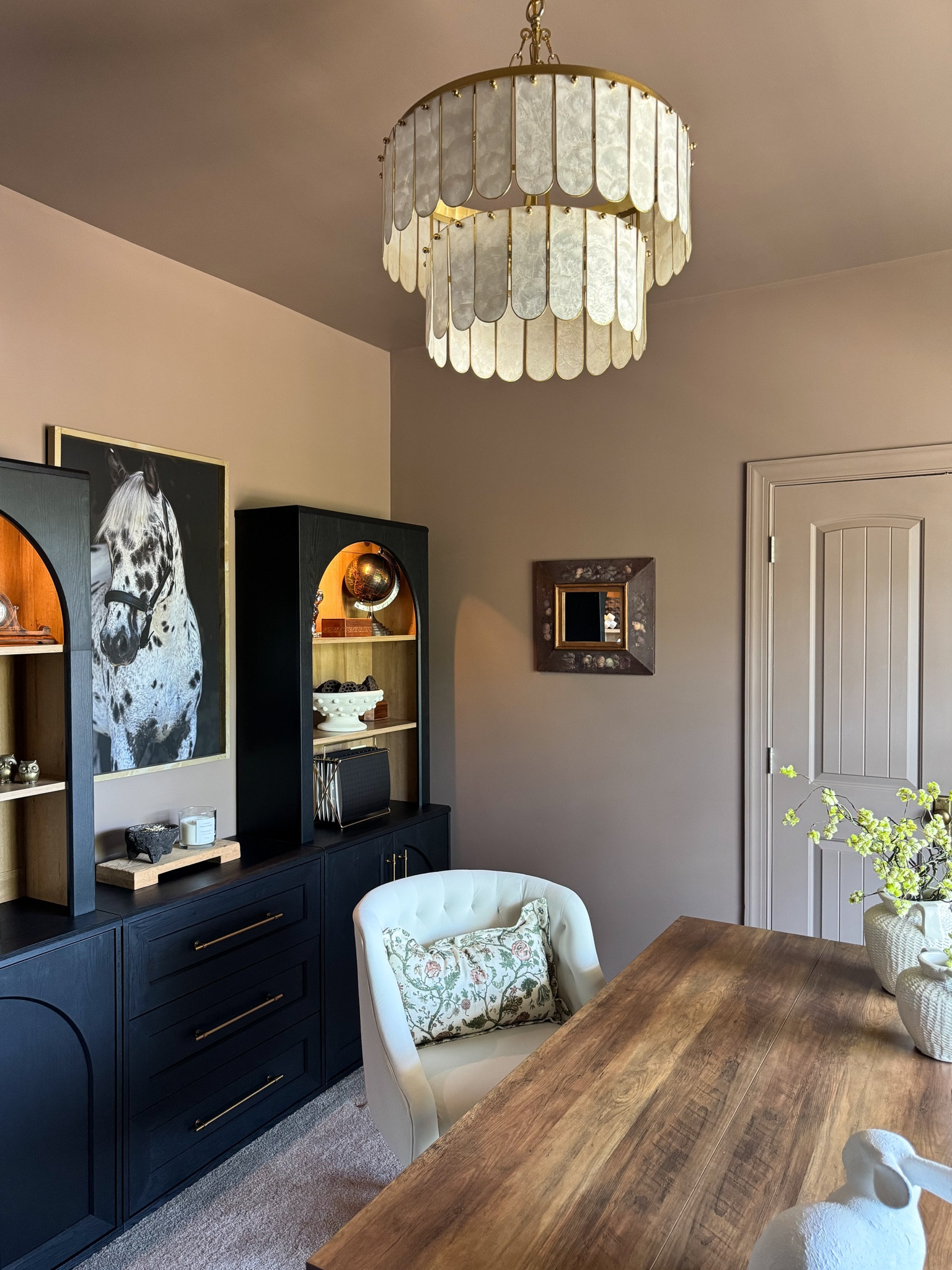 Moody Study!!
My walls are color drenched with Porcini 
by Benjamin Moore🤎

Chandelier, desk, chair, horse art, Mopio Blake storage system, bookcases, dressers, office units, vases, spring stems, mortar, candle, matches, pedestal, grapevine balls, marble sculpture, antique brass 

#LTKHome #LTKstorytime #LTKSeasonal