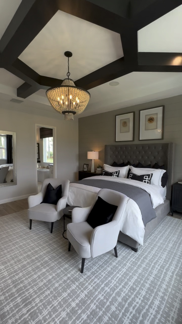 Dramatic primary bedroom with tufted headboard, boho chandelier, and neutral accent chairs with black velvet pillows. 

#LTKHolidaySale #LTKhome