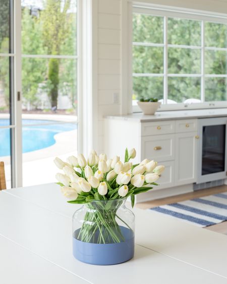Spring decor in our Omaha pool house dining room! I used two bunches of my favorite faux tulips, this paint dipped vase, a blue striped rug and the greenery outside 🤩 Also linking our gold cabinet hardware and white dining table.
.
#ltkhome #ltkseasonal #ltksalealert #ltkfindsunder50 #ltkfindsunder100 #ltkstyletip

#LTKhome #LTKfindsunder50 #LTKSeasonal