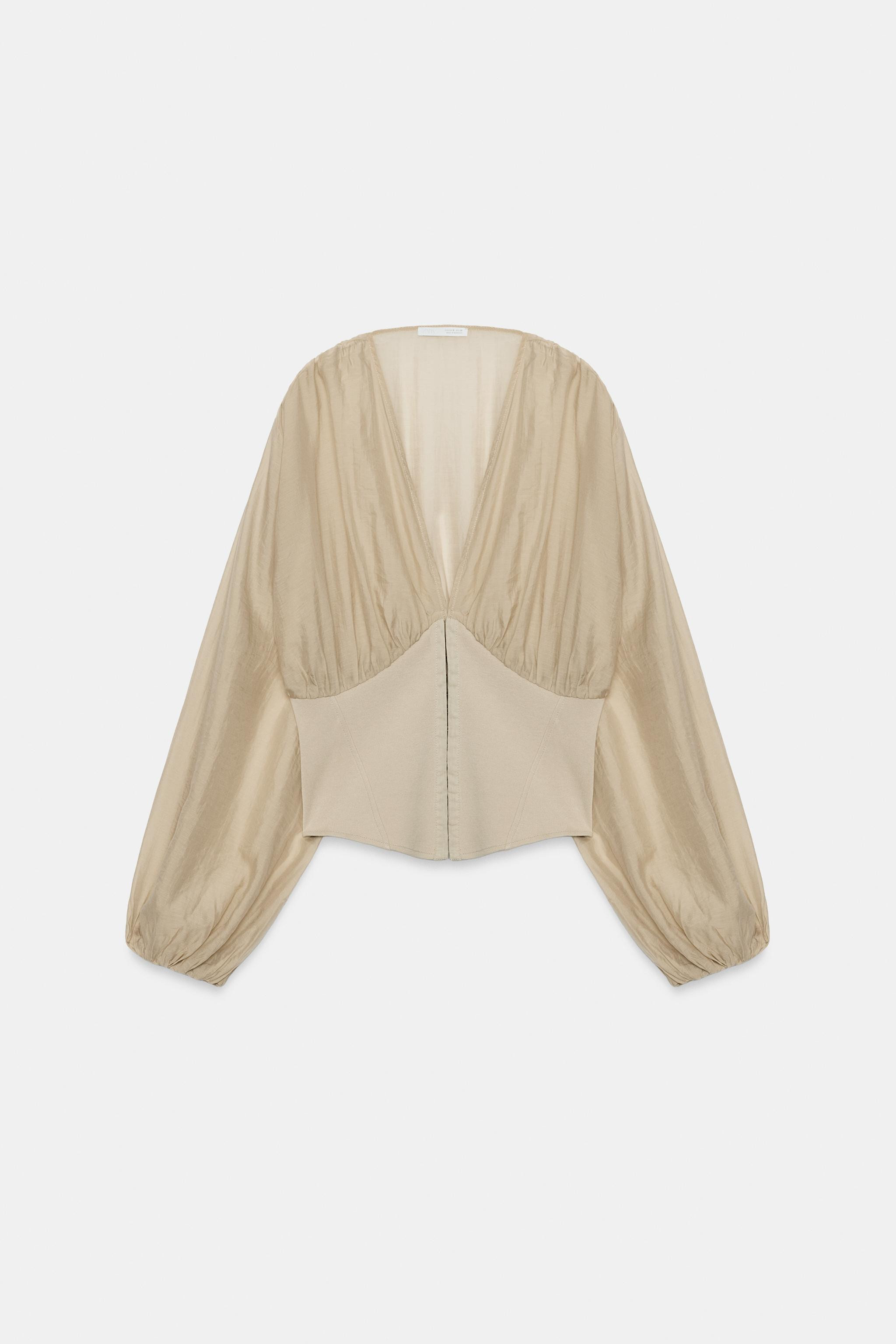 V-neck top featuring long sleeves with elastic cuffs. Corset-style fabric detailing. Front metal ... | Zara NL
