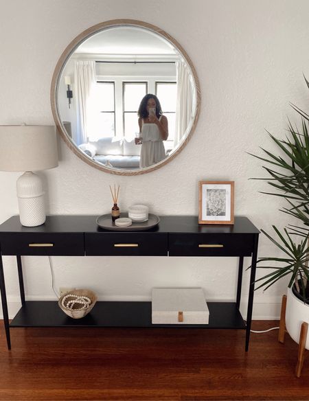 Modern organic entry! Black console table styled with a round wood framed mirror and textured home decor with a natural color scheme. 

#LTKhome #LTKstyletip