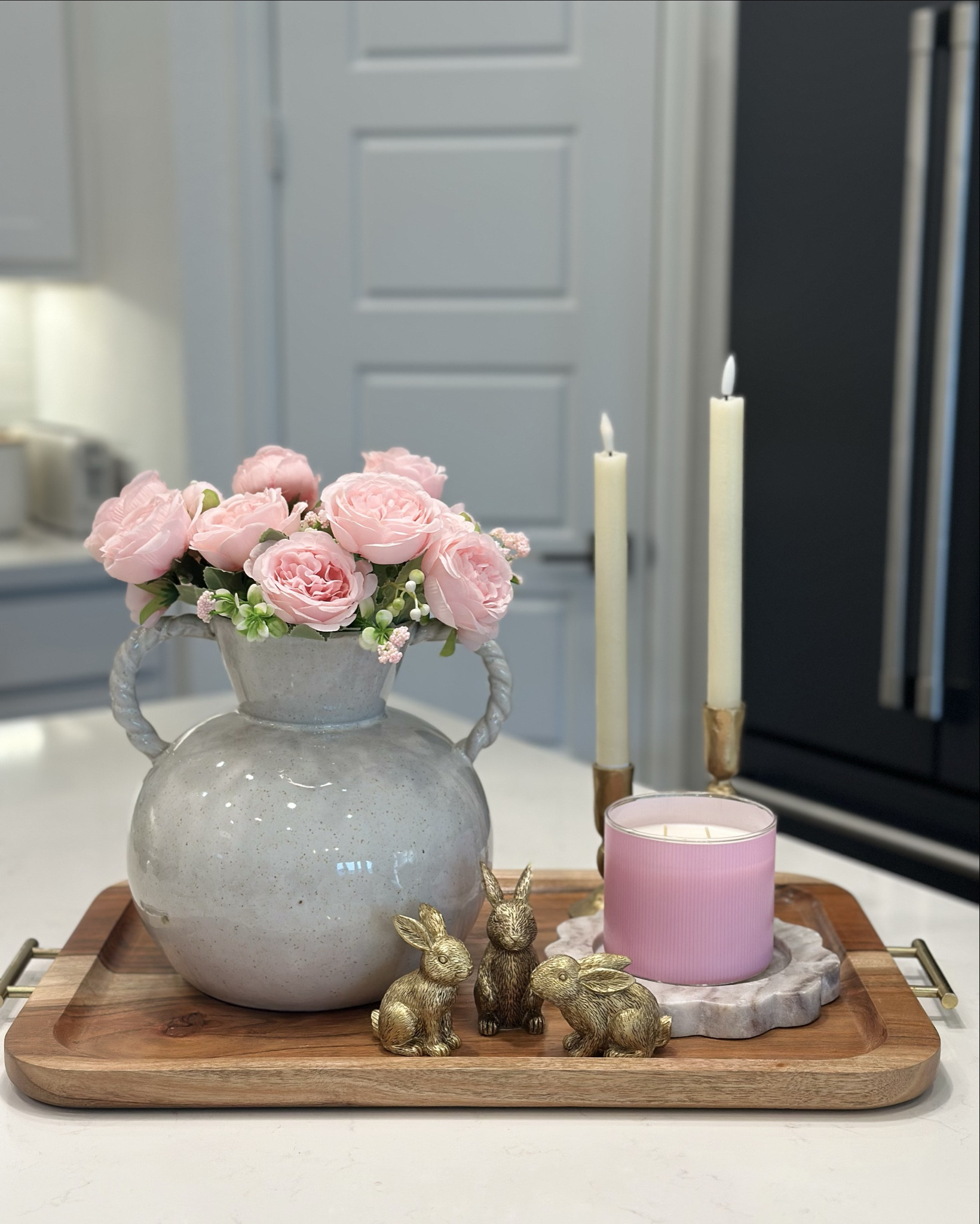 Tray Styling for Spring 

1. Start with a beautiful base
Choose a tray that complements your space. Neutral trays in wood, marble, or white ceramic create a clean foundation that feels timeless.
2. Add height with florals
Fresh or faux flowers instantly bring spring to your space. A simple vase with hydrangeas or soft seasonal blooms adds the perfect pop of life.
3. Layer with books
Stacking one or two small books adds interest and helps elevate other pieces like candles or small decor objects.
4. Include a cozy element
A candle is perfect for creating a warm and inviting feel. Choose a neutral vessel to keep the look calm and cohesive.
5. Add a small decorative accent
A small object like a bunny, decorative eggs, or a natural element brings personality and keeps the tray feeling seasonal.
6. Keep it simple
The key to a beautiful tray is balance. A few thoughtfully chosen pieces will always look more elevated than too many items.
✨ Designer tip:
Try to include three different heights (tall, medium, and low). This creates a layered, styled look that feels intentional and visually interesting.

#LTKHome