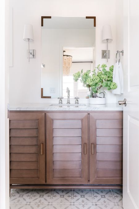 All the details of our small guest bathroom remodel in Omaha! Items include a louvered wood vanity with a Carrara marble countertop, chrome bath faucet, mirror with bracket corners, paint dipped vase with faux viburnum stems, silver wall sconces, and chrome bathroom hardware. See even more details here: https://lifeonvirginiastreet.com/small-guest-bathroom-remodel-reveal/

.
Amazon home decor, target home, target finds, mcgee and co mirror, studio mcgee mirrors, amazon faucets, amazon bathroom accessories, bathroom vanity lighting, wall sconce, bathroom faucet, bathroom flooring, bathroom ideas, bathroom inspiration, amazon bathroom, bathroom hardware, bathroom accessories, bathroom remodel, cement tile, wood vanities, white bathroom, wall sconces, chrome light fixtures 

#ltksalealert #ltkhome #ltkfindsunder50 #ltkfindsunder100 #ltkstyletip #ltkseasonal #ltkkids #ltkfamily 

#LTKSaleAlert #LTKHome #LTKSeasonal