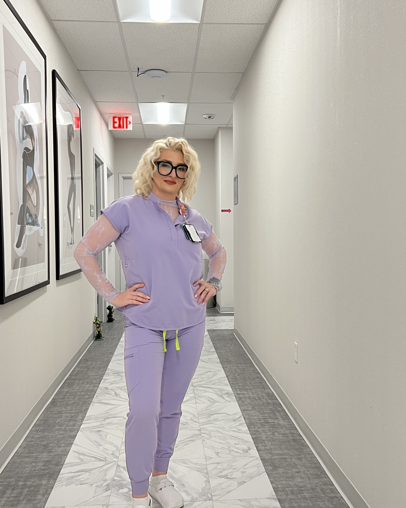 Lavender scrub set styled with a lace long sleeve layer and white work shoes. The lace detail is what makes this outfit feel a little more put together. Linked what I could and added similar options.