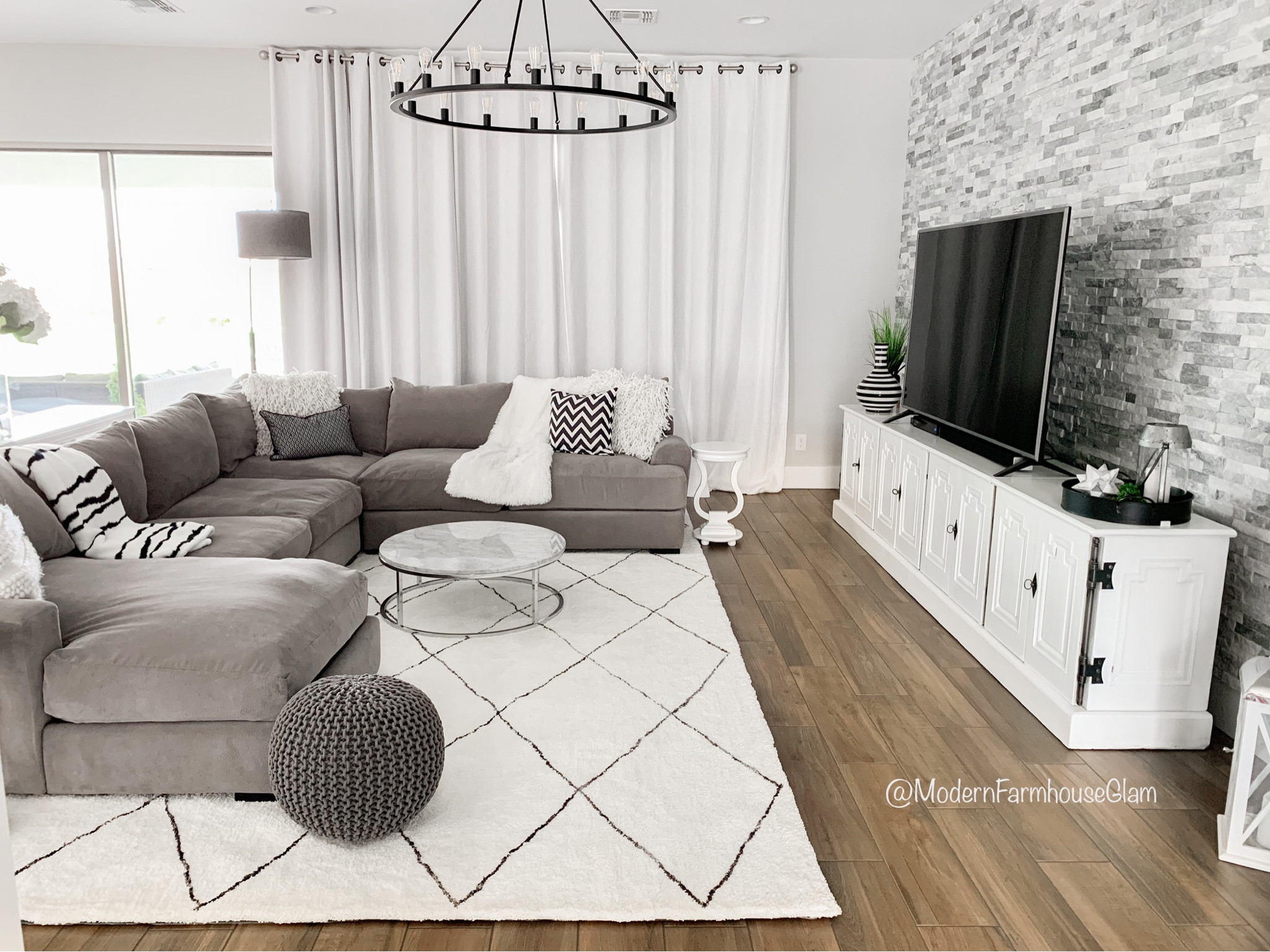 Living room at Modern Farmhouse Glam. White rug sofa sectional couch media console table black chandelier wagon wheel lighting lamp home decor 

#LTKsalealert #LTKhome