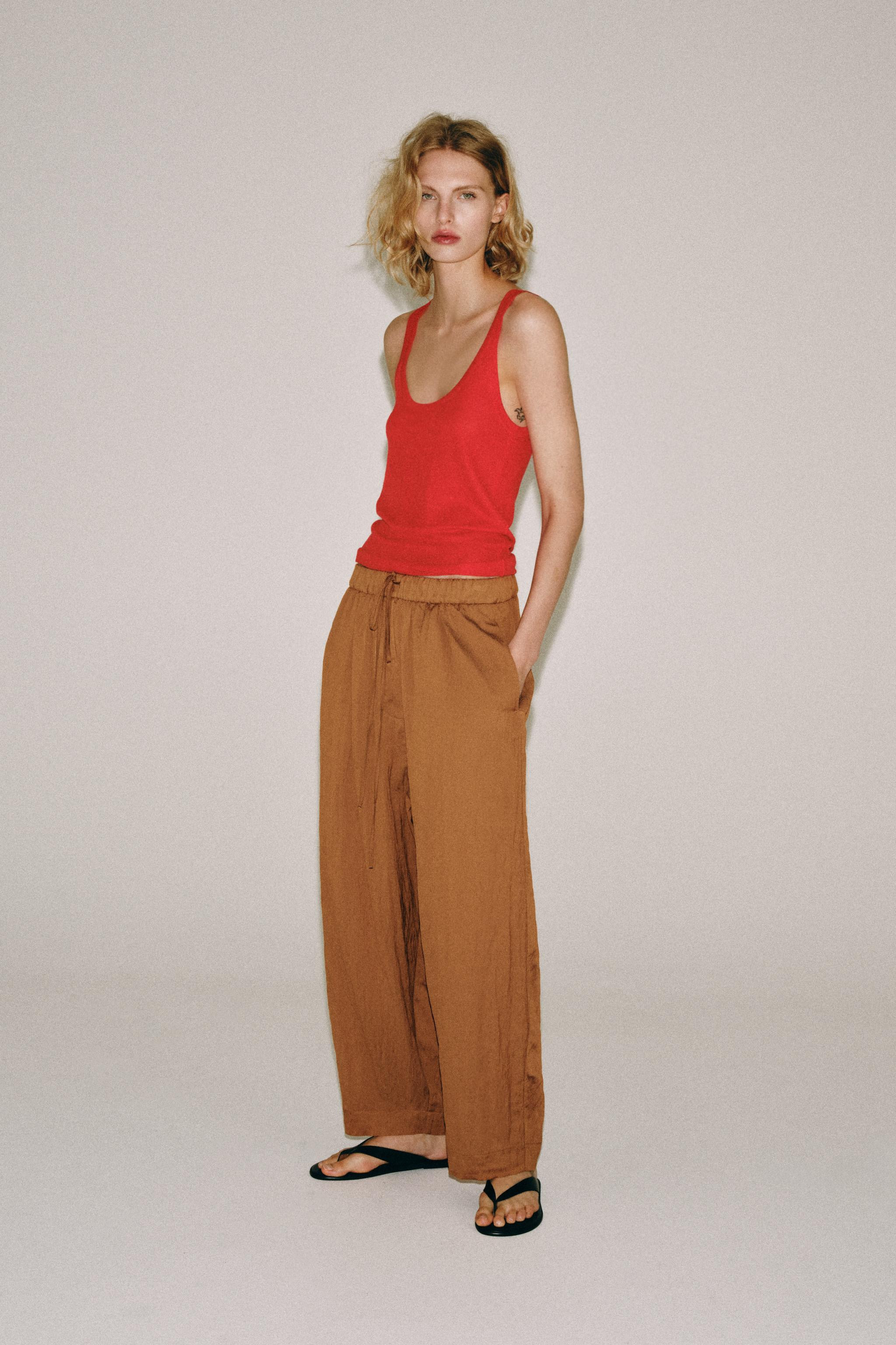 ZARA WOMAN COLLECTIONTrousers made from a viscose blend yarn. Mid-waist with an adjustable elasti... | Zara UK