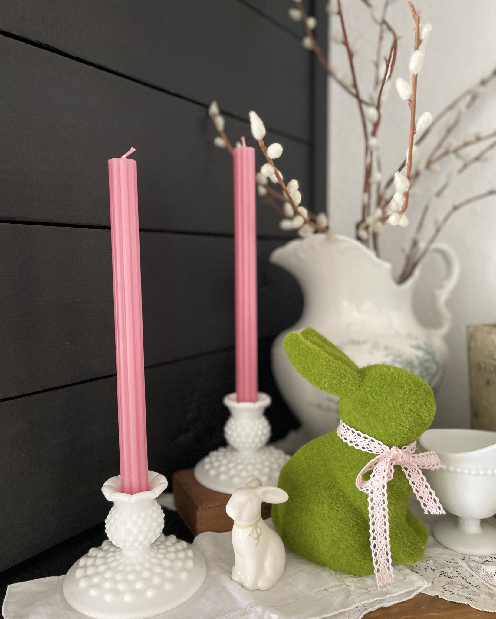 Spring has sprung! 
With a vintage aesthetic mixed with vibrant green and pastel pink, the mantel is bursting with Spring color. Moss bunnies and variations of pink ribbon round out the vignette. 

#LTKHome #LTKSeasonal #LTKFindsUnder50