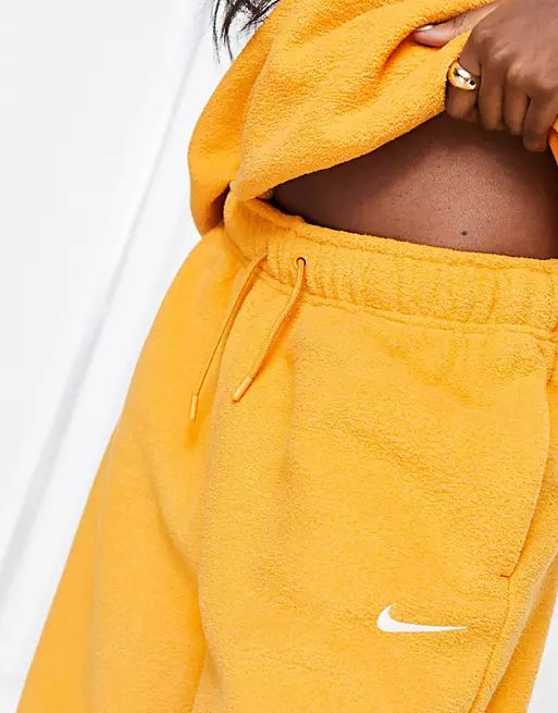 Nike mini swoosh plush high rise joggers in yellow | ASOS (Global)