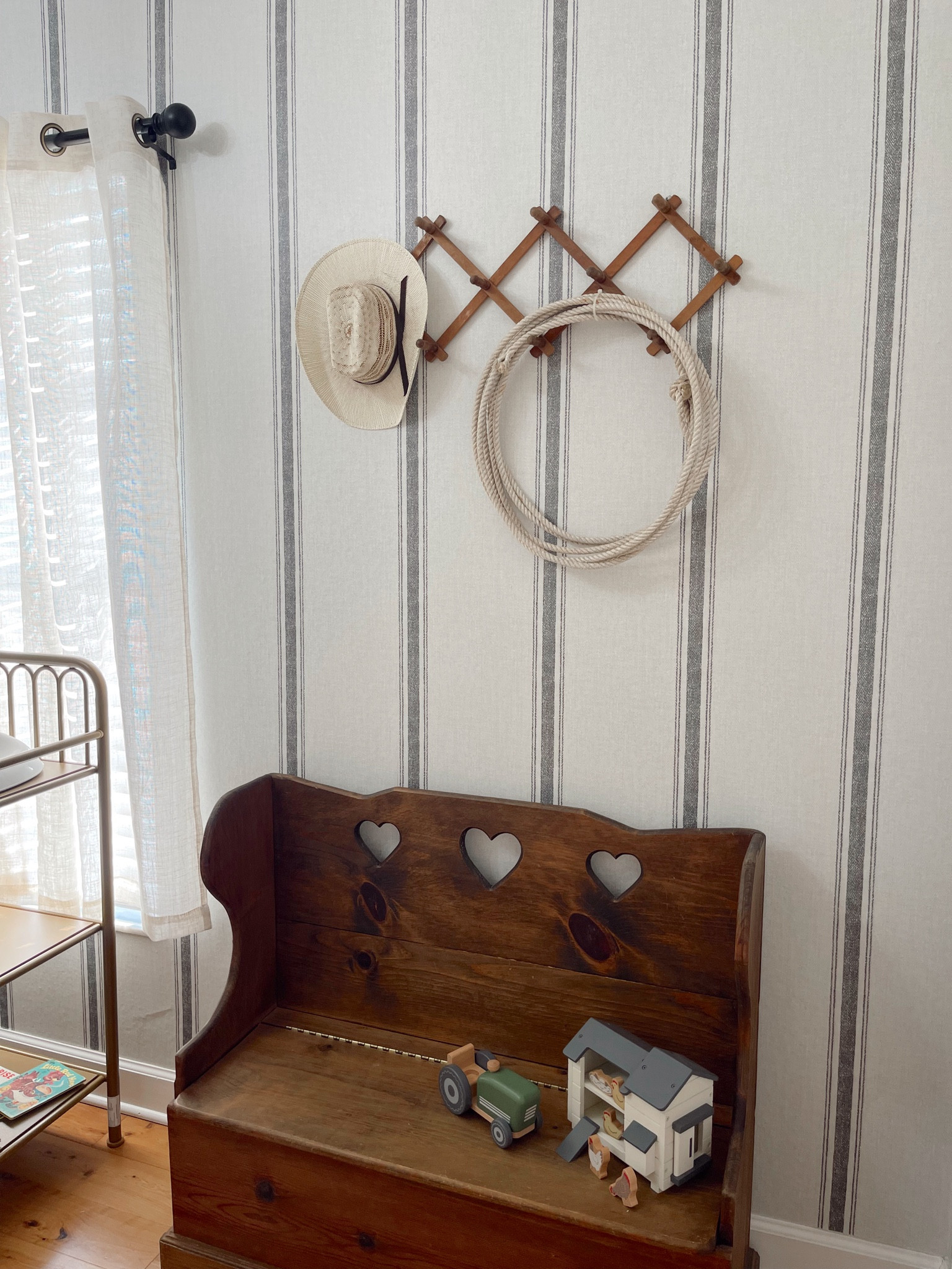 Western baby boy nursery with antique items and vintage cowboy decor! This peel and stick striped wallpaper from Amazon was super easy to apply & is damage free! The wooden antique toy box is a family heirloom but I linked a similar one you can find on Amazon, Etsy has cute options as well. The wood accordion style wall hooks with the toddler cowboy hat and lasso were the perfect touch for our little cowboy in the making. The gold vintage looking changing table is an affordable option and from Amazon as well as the wipeable rubber changing pad that’s comparable to the keekaroo changing pad  

#LTKBaby #LTKHome #LTKFamily