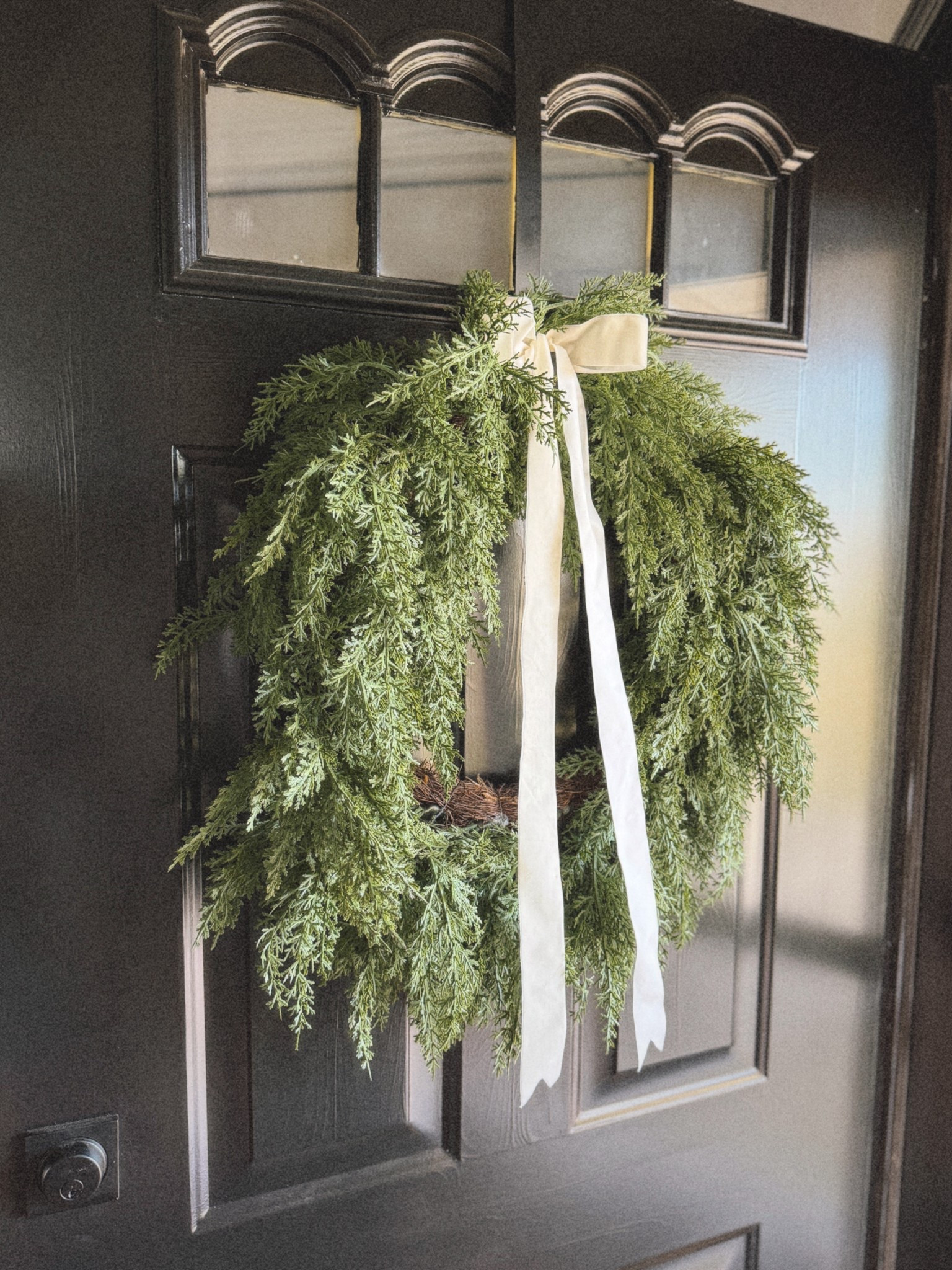 Classic and timeless 🎄🤍 A simple greenery wreath with a ribbon is my favorite way to dress up the front door for the holidays. It’s neutral, cozy, and makes the whole entry feel festive without being overdone.

#ltkhome #christmasdecor #holidaydoor #neutralchristmas #holidayhomedecor #ltkholiday
