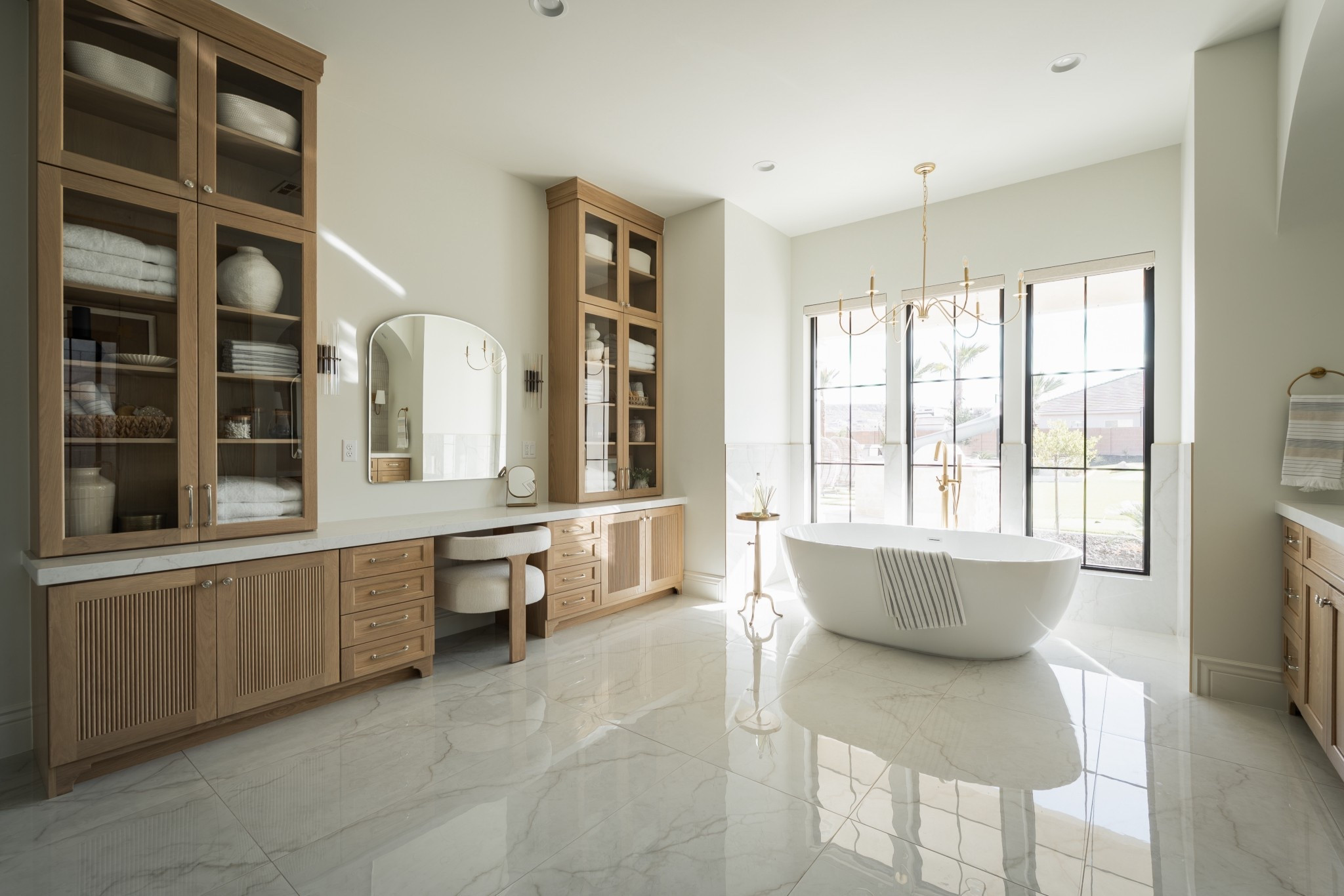 This is where restraint meets detail.

Warm wood brings depth.
Polished stone reflects light.
Glass cabinetry turns everyday storage into something intentional.

Nothing excessive, just everything considered.