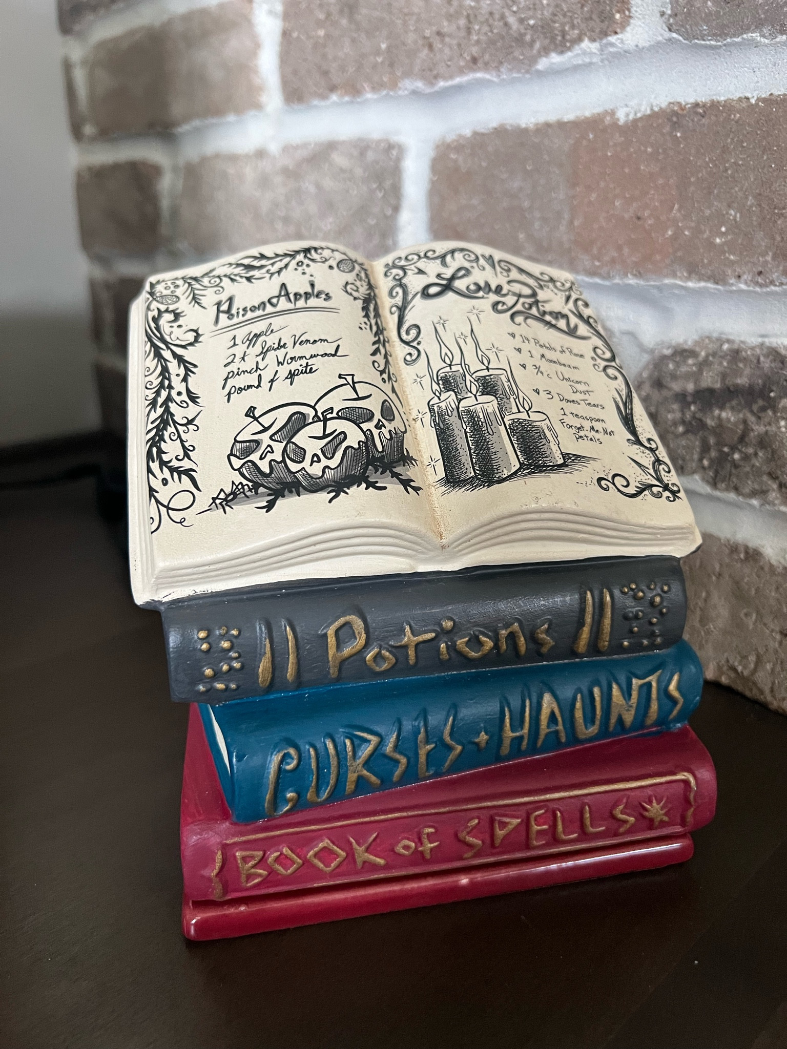 This is a candle wax warmer! Can you believe it? It’s so cool! Set up like a book of spells for Halloween. Even has a full poison apple and love potion spell written on the top. The books are “potions”, “curses and haunts” and “book of spells”. So much detail and it’s only $17! 

The wax goes in the bottom and it lights up from behind  

#LTKhome #LTKsalealert #LTKHalloween