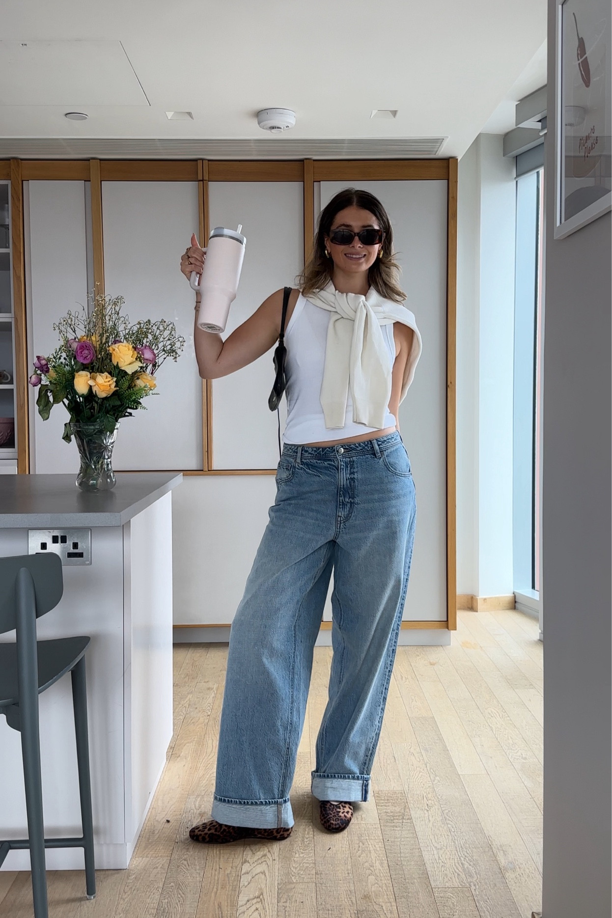 ootd ft new leopard ballet flats 🐆🐆🐆

white tank ribbed basic capsule wardrobe, white knit sweater Uniqlo cream, baggy boyfriend jeans, pink Stanley cup, tortoise shell sunglasses rectangular mango & other stories, H&M Mary Jane animal print ballet flat, black shoulder bag jacquemus gold jewellery 