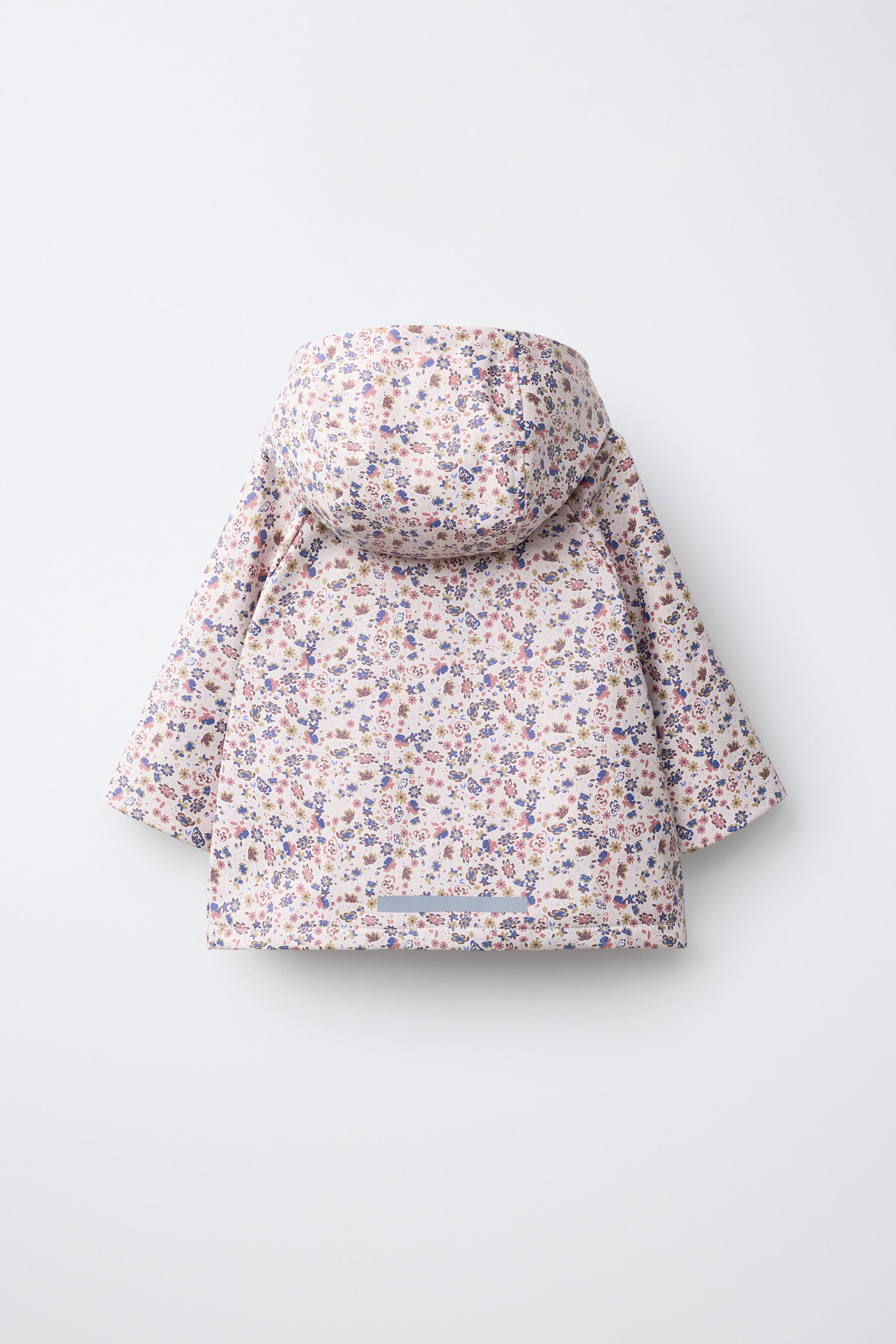 Water-resistant fabric raincoat. Features a hood, high neck, and long sleeves. Front zip closure ... | Zara US
