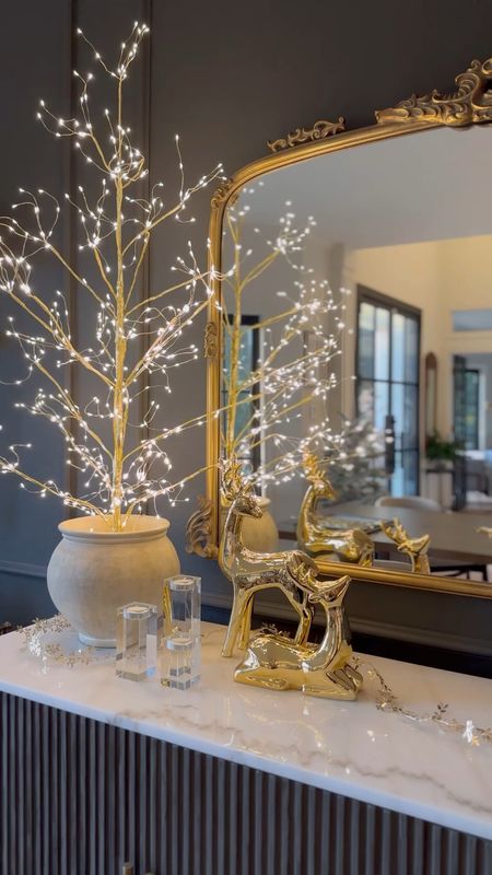 Holiday sideboard styling including these beautiful, affordable gold reindeer from Target and this gorgeous lit tree! I love that the base is this is gold. I unscrewed the bottom to style it in this post - I used styrofoam inside to make it stand up!

#LTKVideo #LTKHoliday #LTKhome