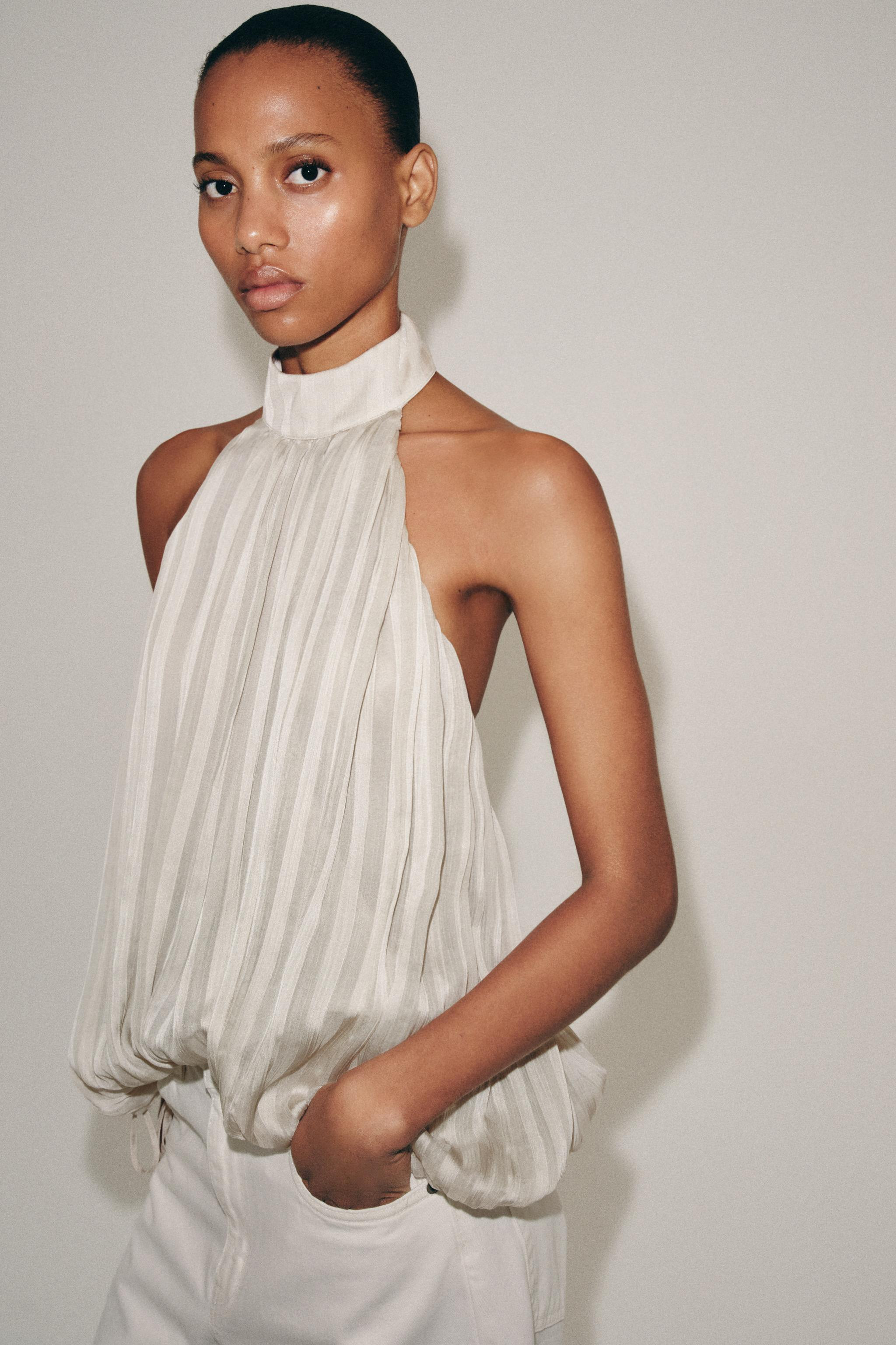 ZARA WOMAN COLLECTIONHalter neck top with open back. Pleated fabric detail. Adjustable puffed hem... | Zara US