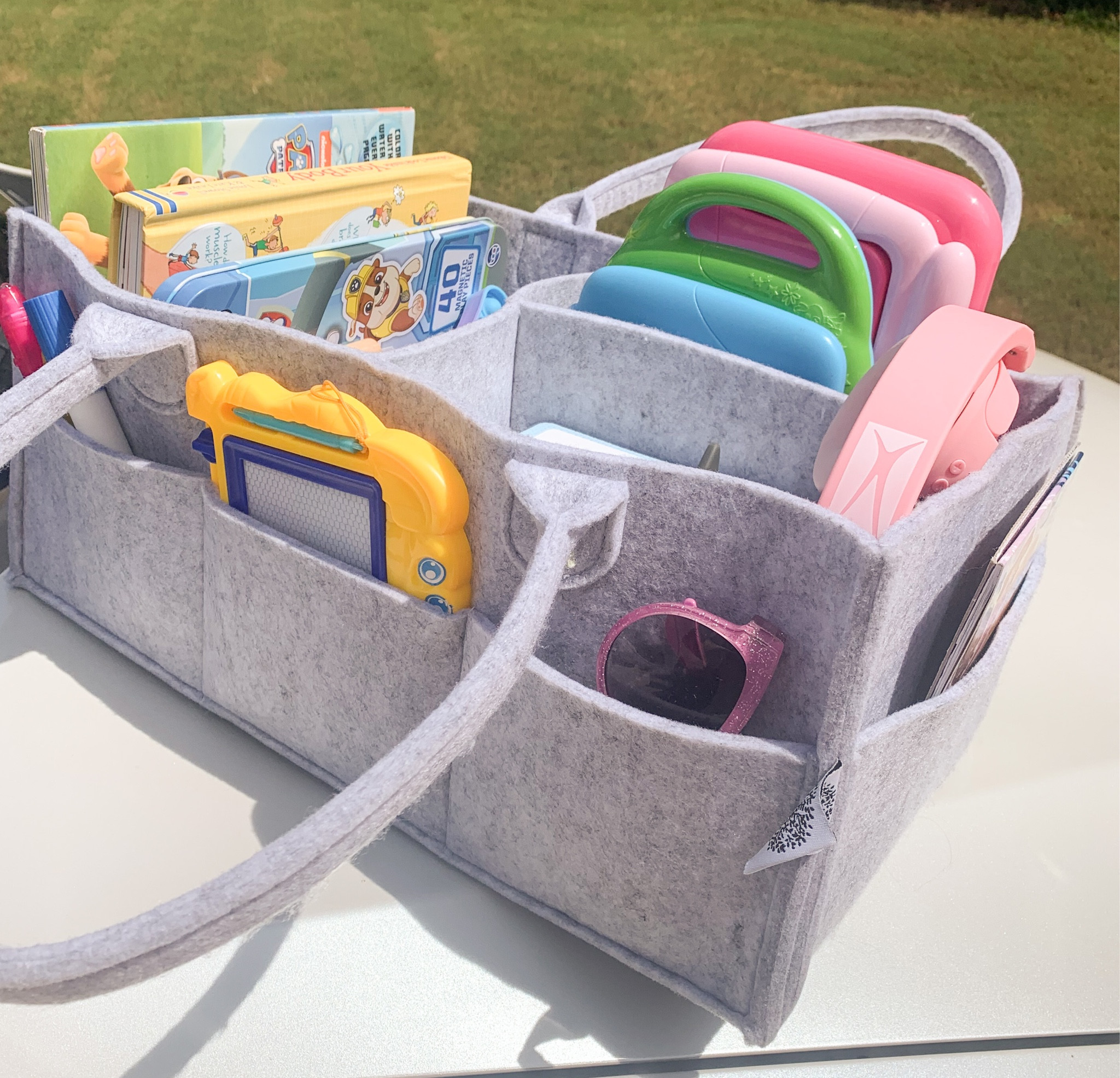Most kids hate long car rides, but this hack makes it a little more bearable. 

The Traveling Toy Box

This organizer is meant to be used as a diaper caddy but it conveniently fits between two bulky car seats and can store A LOT of toys. Bonus, kids can reach in it themselves so that you don’t have to. Here’s what I stored in mine:

🚗 Tonies Box + Characters
🚗 Bluetooth Headphones 
🚗 Magnetic Creations Tin 
🚗 LCD Writing Tablets
🚗 Leapfrog laptop 
🚗 Handheld water game
🚗 Etch a sketch
🚗 Flash cards 
🚗 Fidget Poppers 
🚗 Water Wow Books
🚗 Imagine Ink Marker Books 
🚗 Sticker books

And the best part is that once you reach your destination, you can pack everything back into the caddy and CARRY it inside so that your kids have plenty to play with wherever you’re staying. 