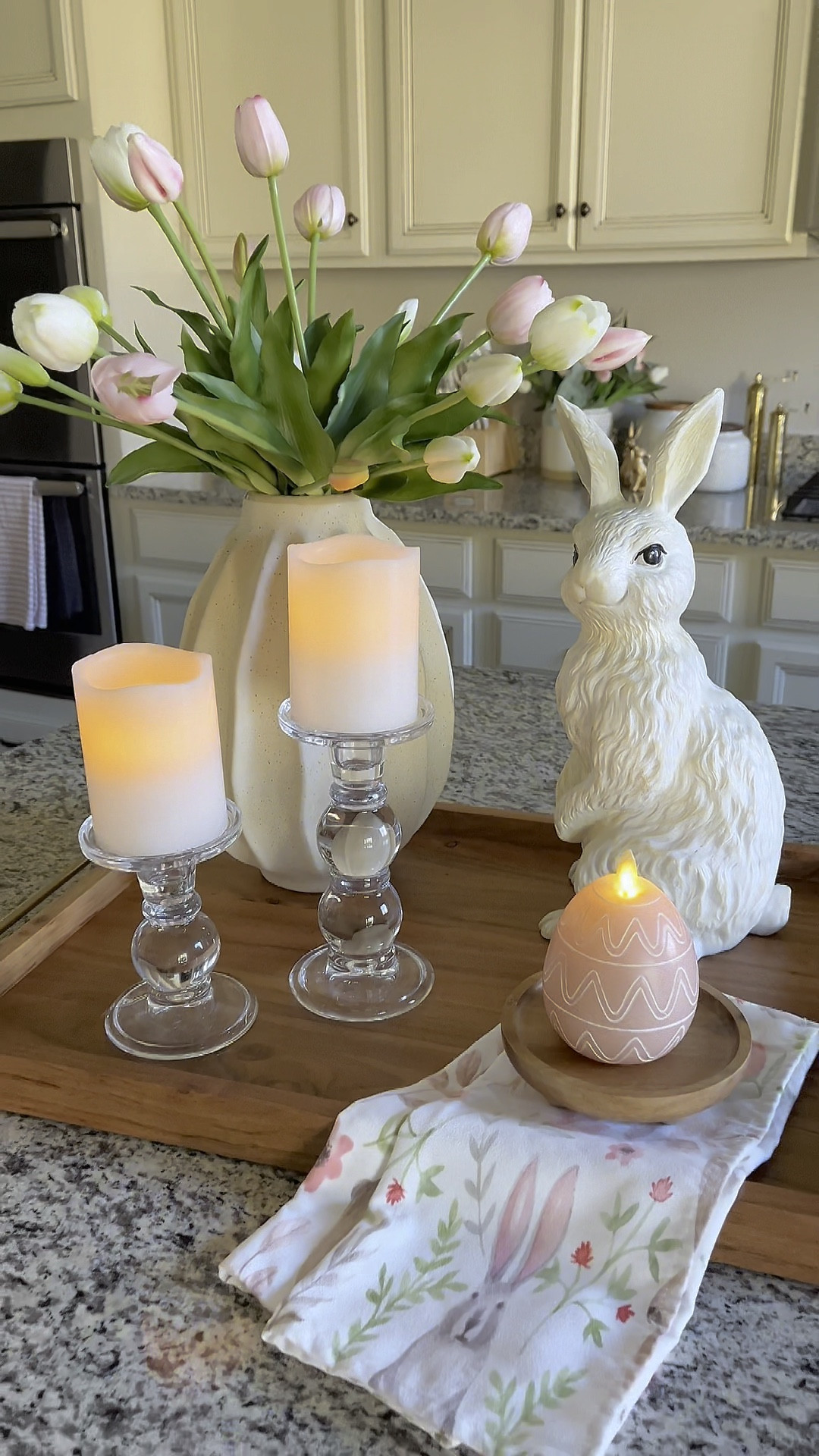 Easter tray styling!  Follow @lifeinmyarizonahome on Instagram for more inspiration. 

I gave my wooden tray an update for spring and Easter.   It’s perfect for a counter top or centerpiece.  How adorable is this egg candle from Luminara?!  Their flameless candles have become my favorite and I absolutely love the flickering flame that’s so realistic looking and the convenience of a timer. 

Wood rectangle tray | Wavy Ceramic Vase | real touch tulips | bunny | glass pillar candle holder | wood riser | luminara flameless Easter egg candle | Easter kitchen towel 

#LTKWatchNow #LTKSeasonal #LTKHome