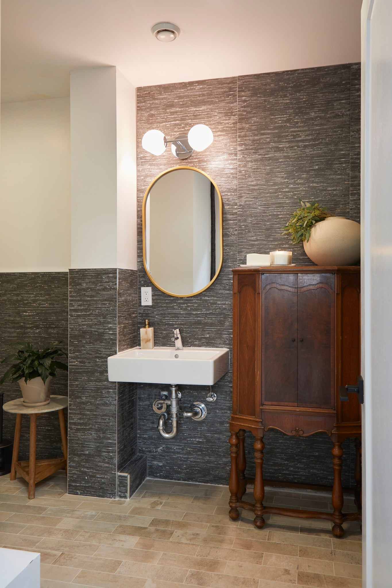 The bathroom at EKAH turned out so lovely with such minimal effort.

We didn’t have it in the budget to take down the rough masculine tile that existed in the space, so we worked with it by leaning into the natural stone texture and accented it with vintage woods, soft softened brass and creamy accessories. 

We had pulled some wallpapers to hopefully someday add around the tile, to blend the look and even further elevate the space, but that will come with time. For now, it’s warm and welcoming as it is 💛

We loved working on this acupuncturist space in Jersey City and it’s been so fun building these posts to share them with our mutual audiences! 

#LTKHome #LTKActive #LTKStyleTip
