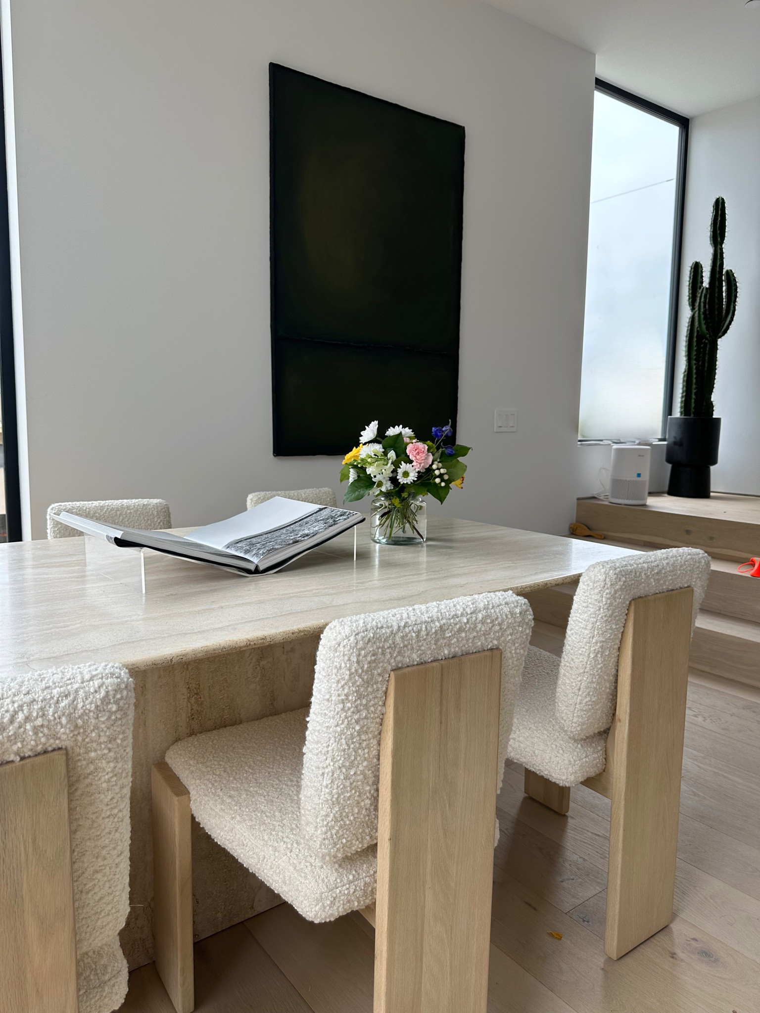 Dining room is coming together. Obsessed with this vintage solid marble dining table 💖 The oversize art ties it all together and adds depth. #cb2 #travertinemarble #fineart #cactus #interior design #acrylic #coffeetablebook #boucle #neutrals 

#LTKfamily #LTKhome #LTKsalealert
