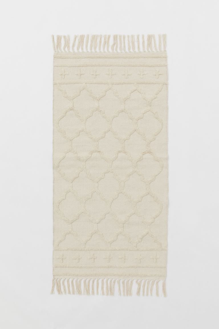Rectangular rug in woven fabric made from recycled cotton with a tufted, same-color pattern. Tass... | H&M (US + CA)
