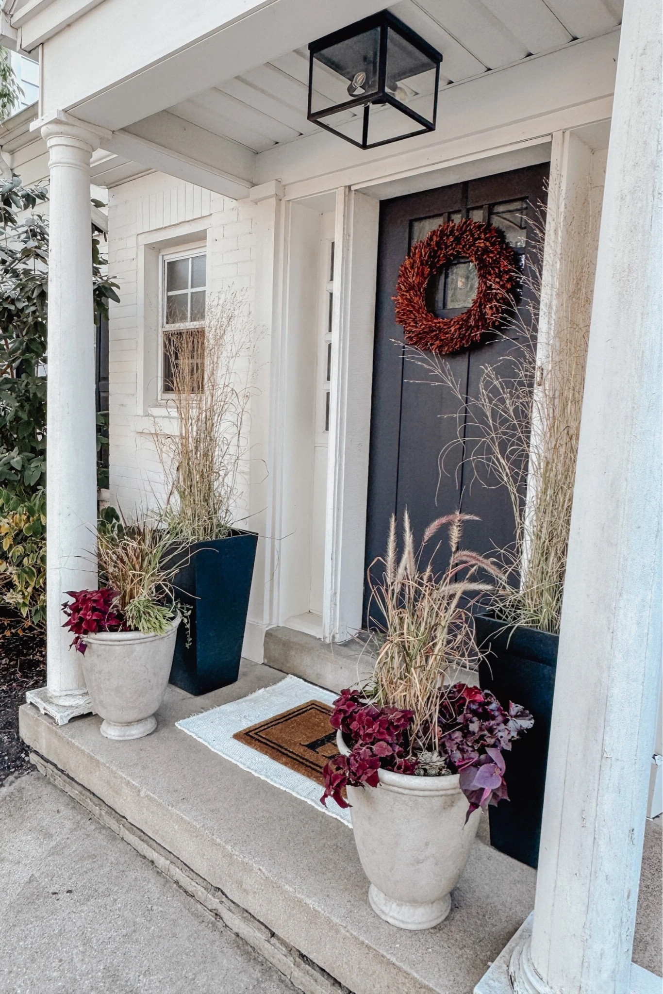 Fall front porch decor using a pretty red boxwood wreath, layered rugs, and ornamental grasses in a neutral color palette 🍂

#fallfrontporch

#LTKStyleTip #LTKHome #LTKSeasonal