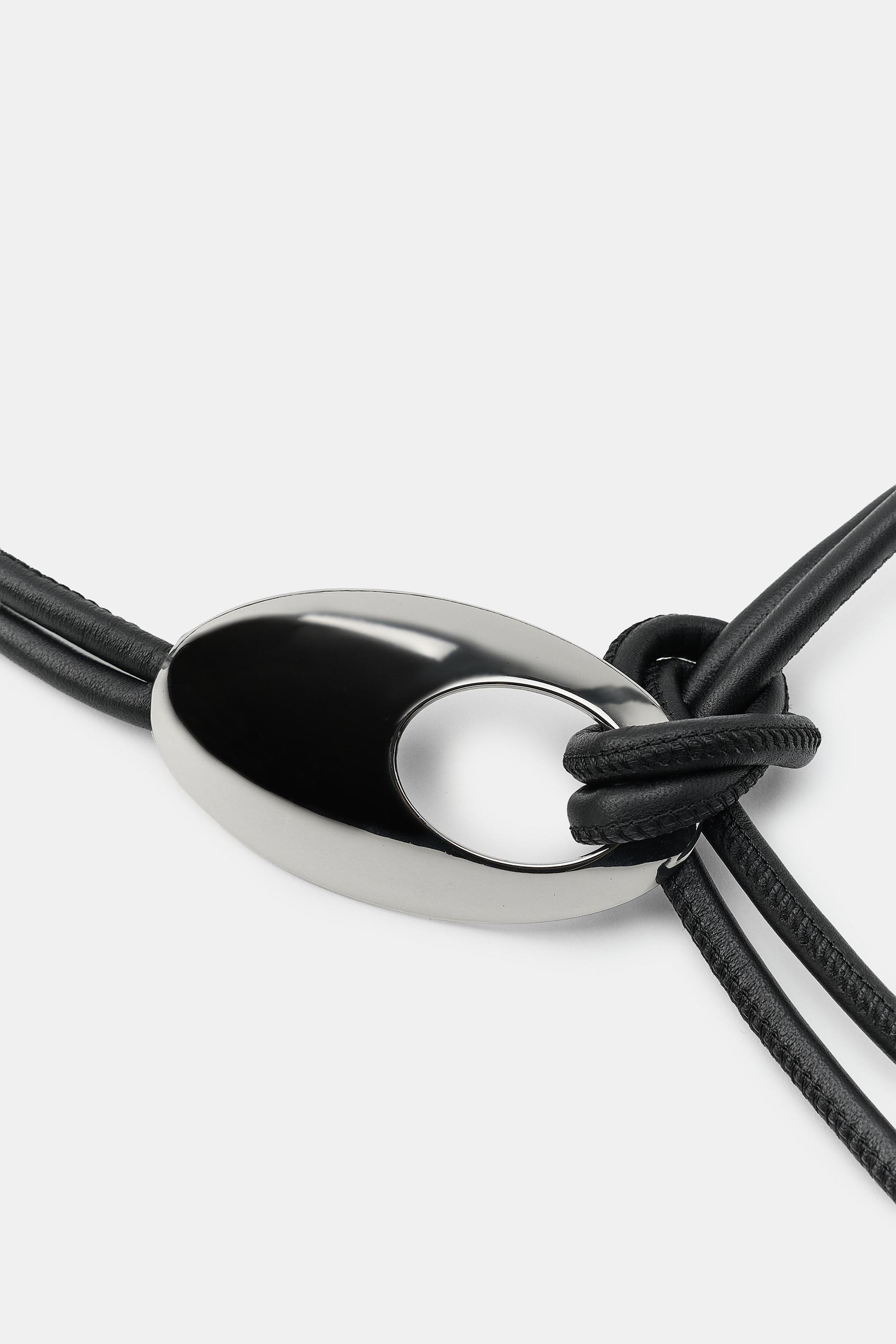 Double-cord belt crafted from 100% leather. Features an embossed oval metallic buckle. | Zara US